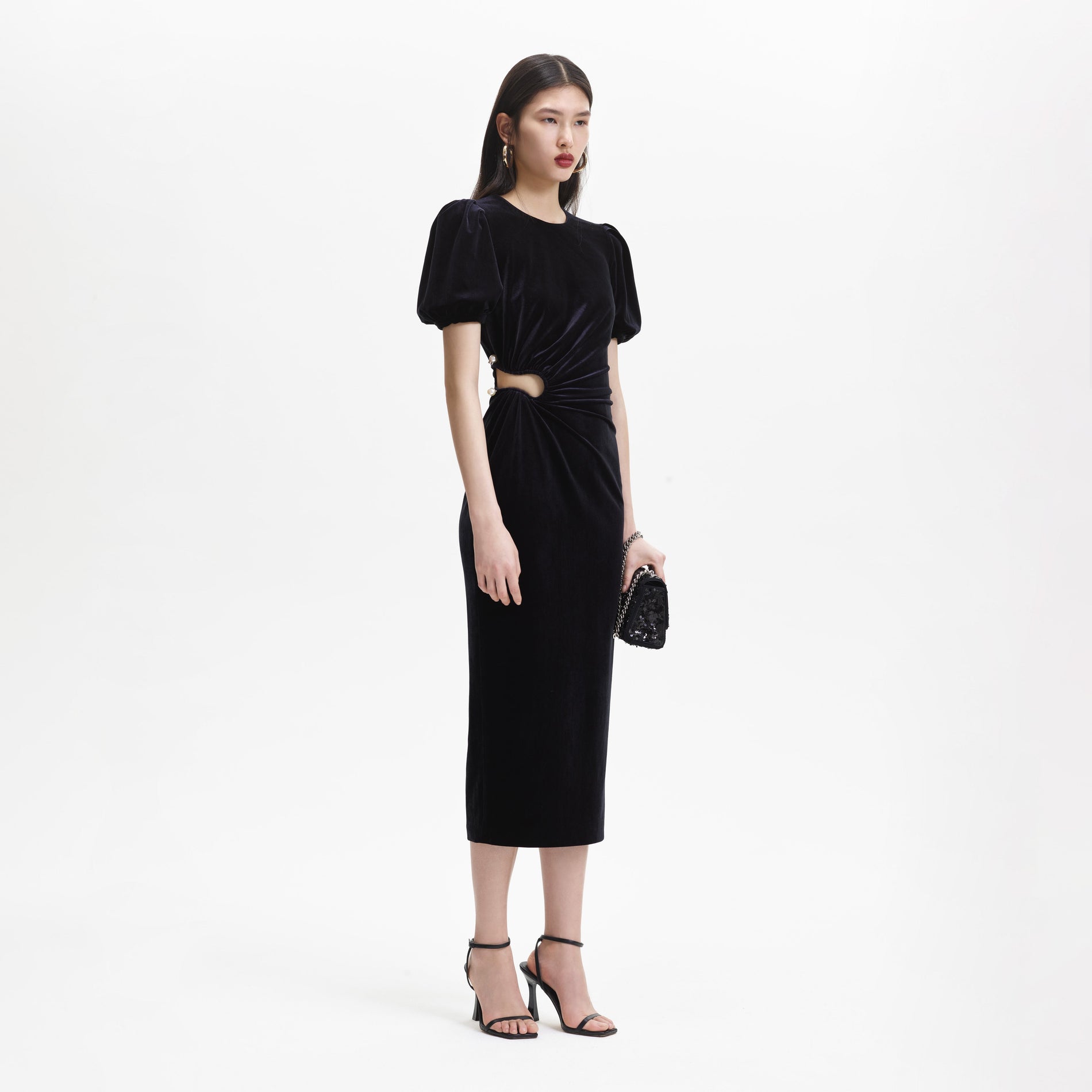 Side view of a woman wearing the Black Velvet Cut Out Midi Dress