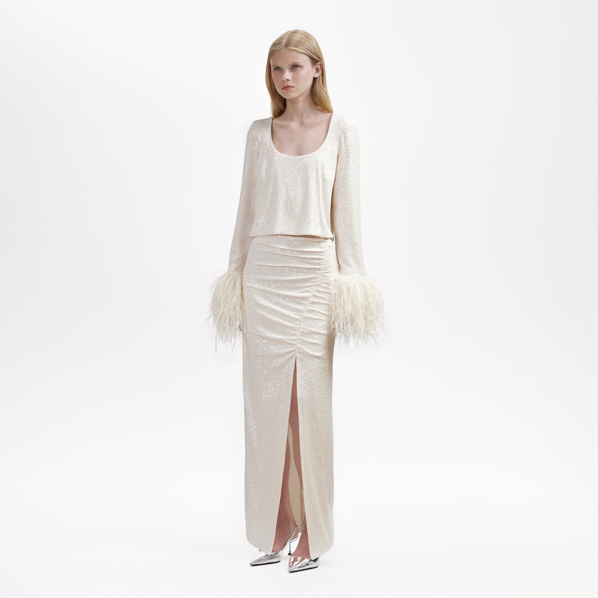 A woman wearing the Cream Sequin Feather Top