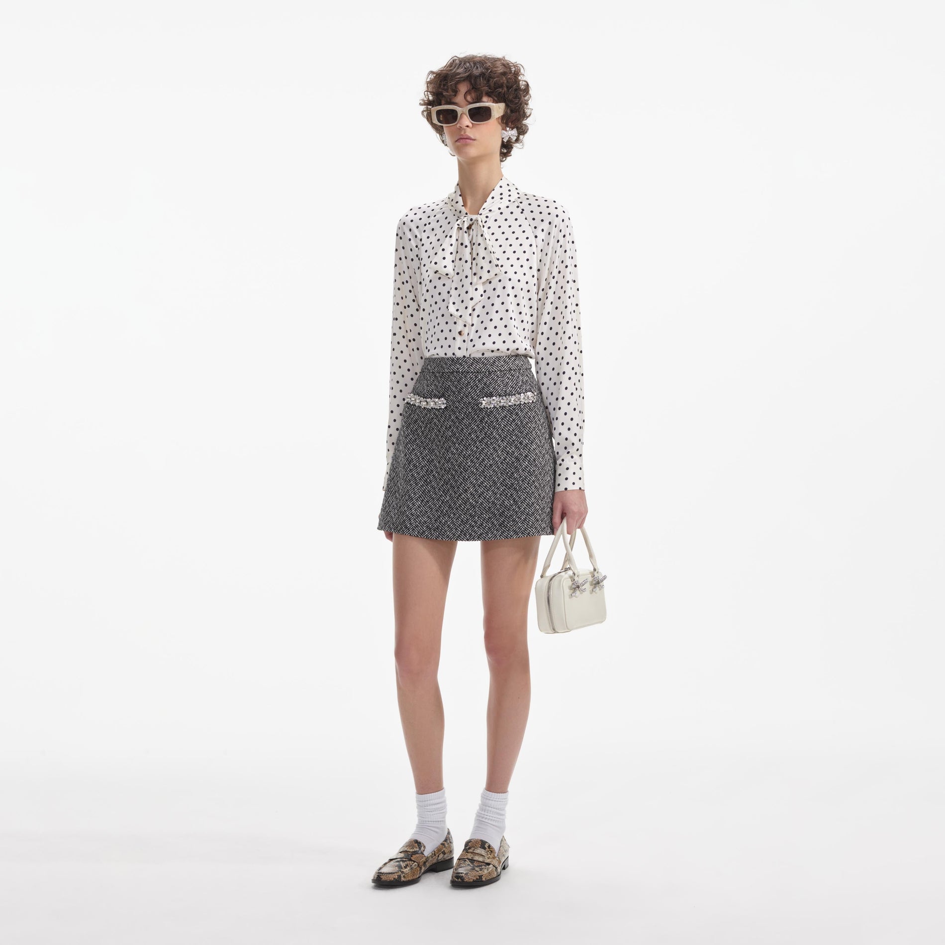 Side view of a woman wearing the Cream Polka Dot Satin Blouse