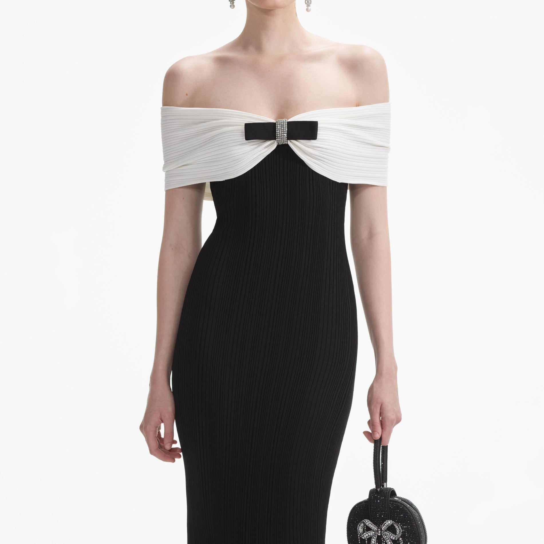 A close up of a woman wearing the Black Knit Bow Midi Dress