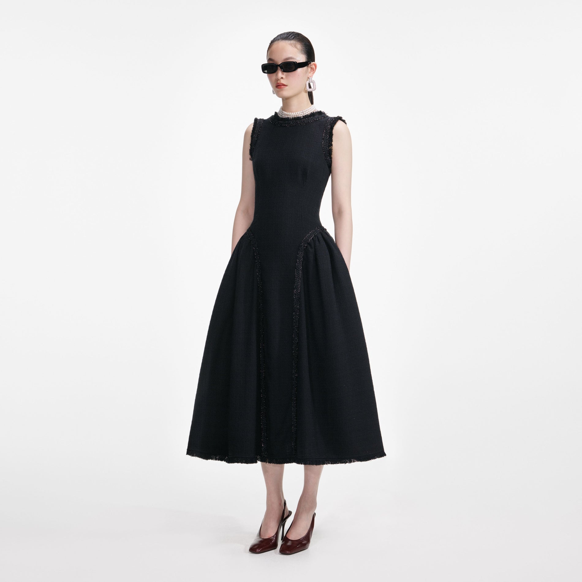Side view of a woman wearing the Black Boucle Sleeveless Midi Dress