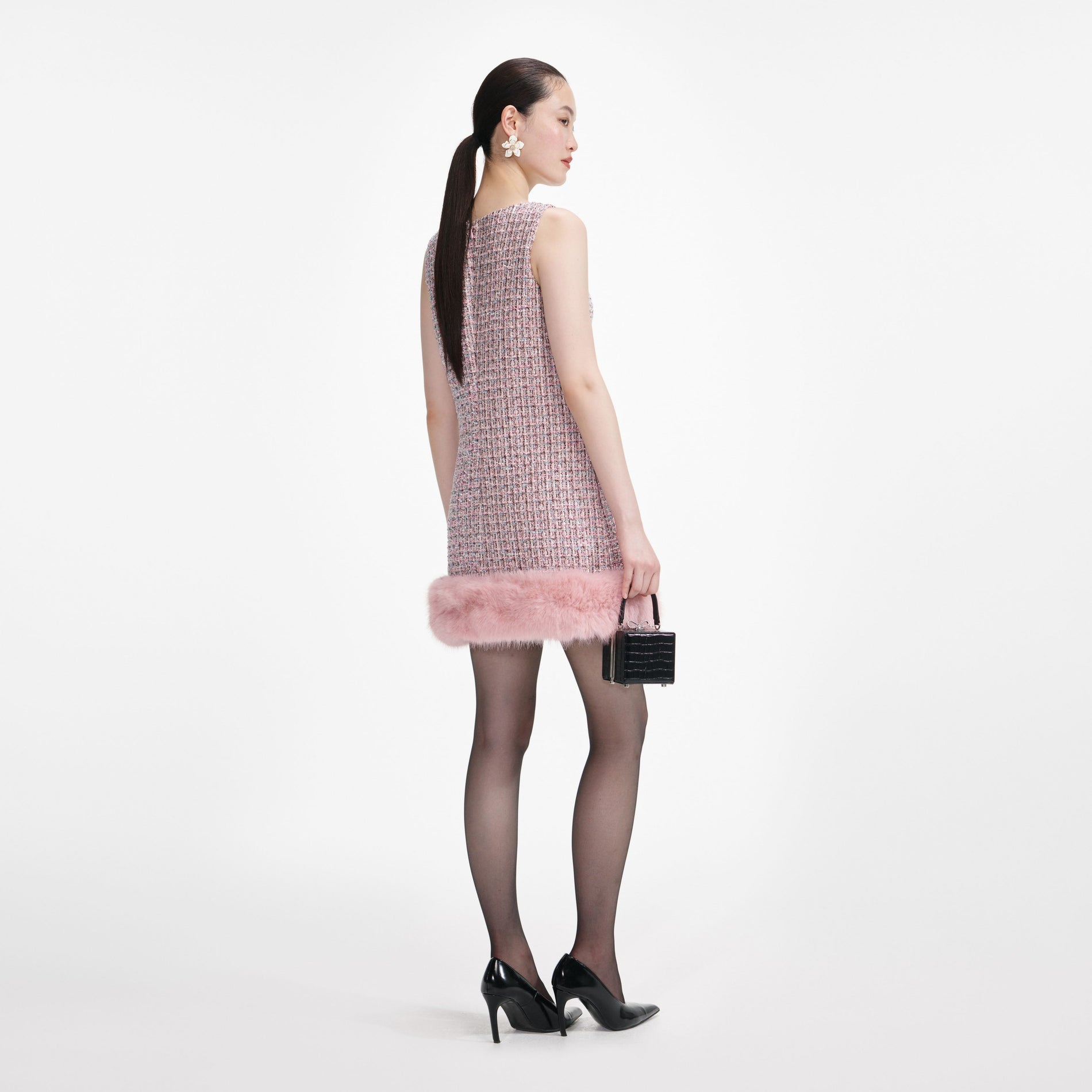 Back view of a woman wearing the Pink Boucle Fur Hem Mini Dress