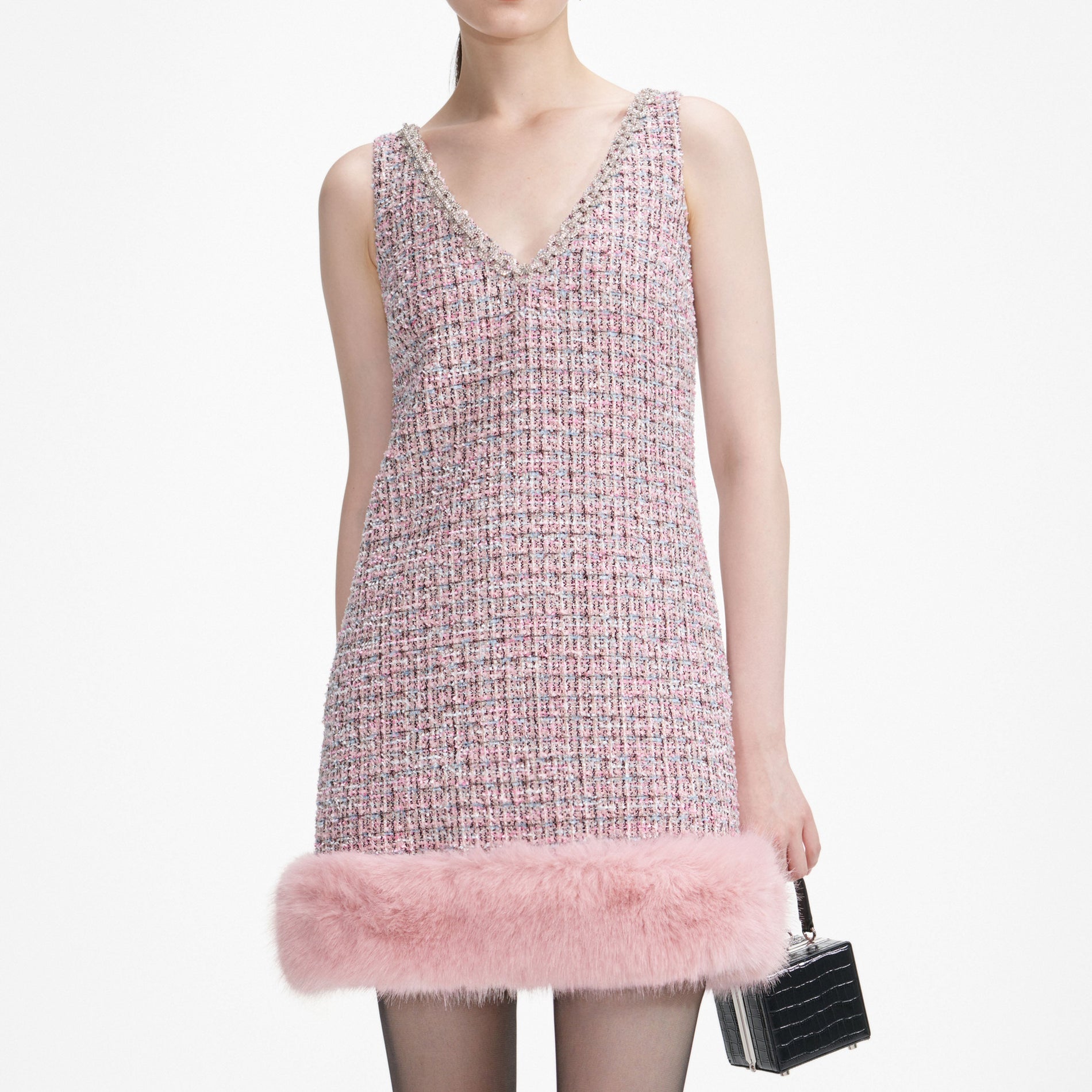 A close up of a woman wearing the Pink Boucle Fur Hem Mini Dress