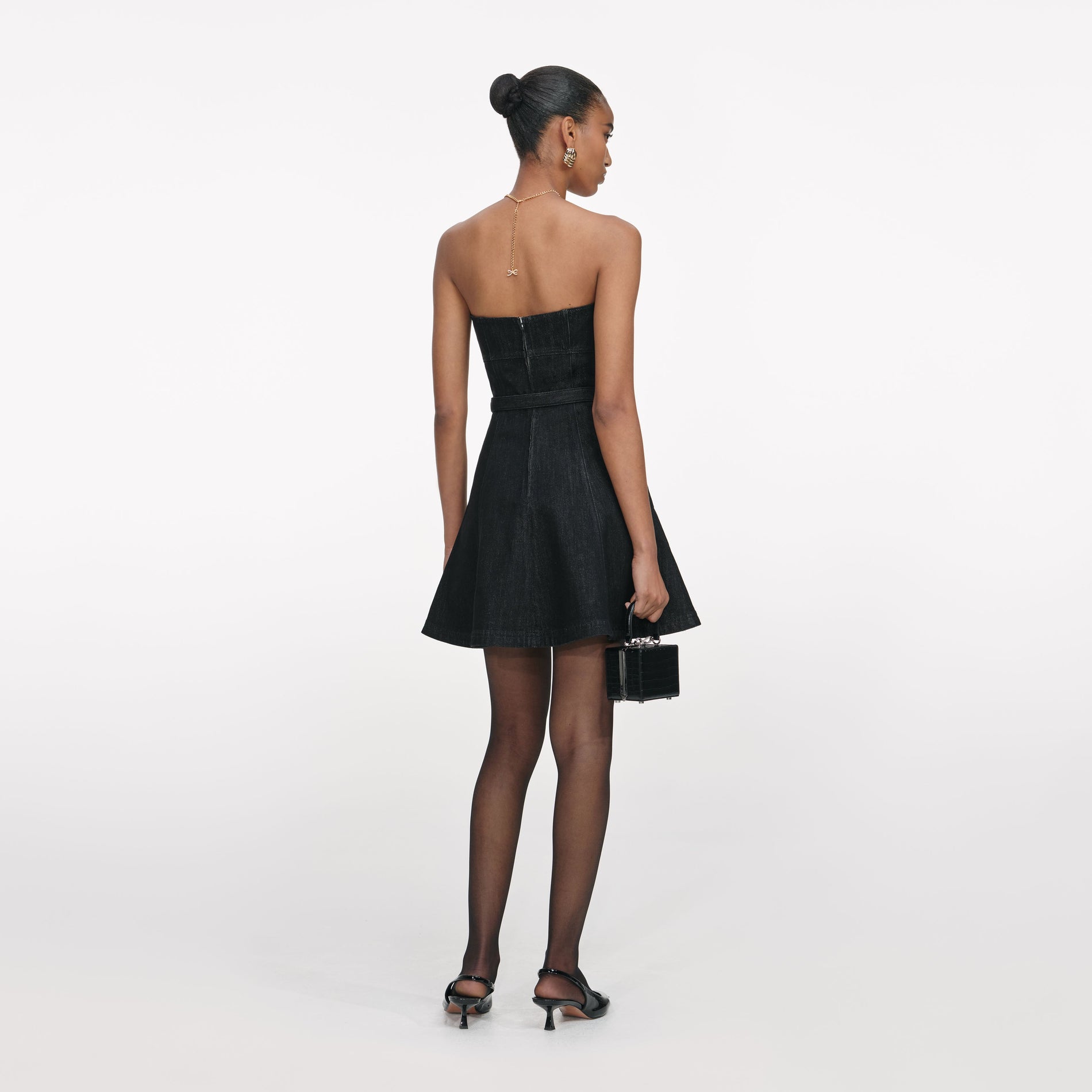 Back view of a woman wearing the Black Denim Bandeau Mini Dress