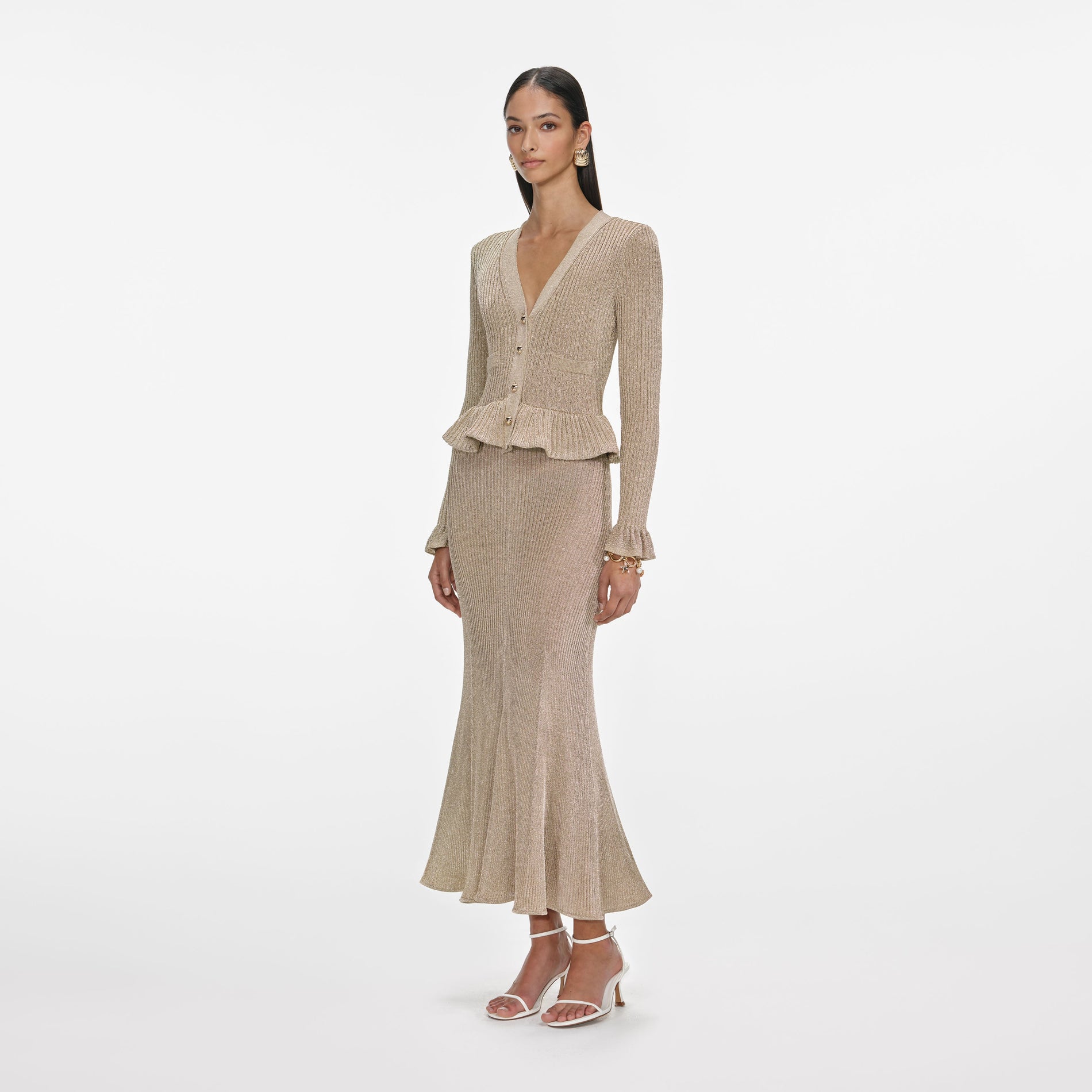 Side view of a woman wearing the Gold Lurex Peplum Knit Midi Dress