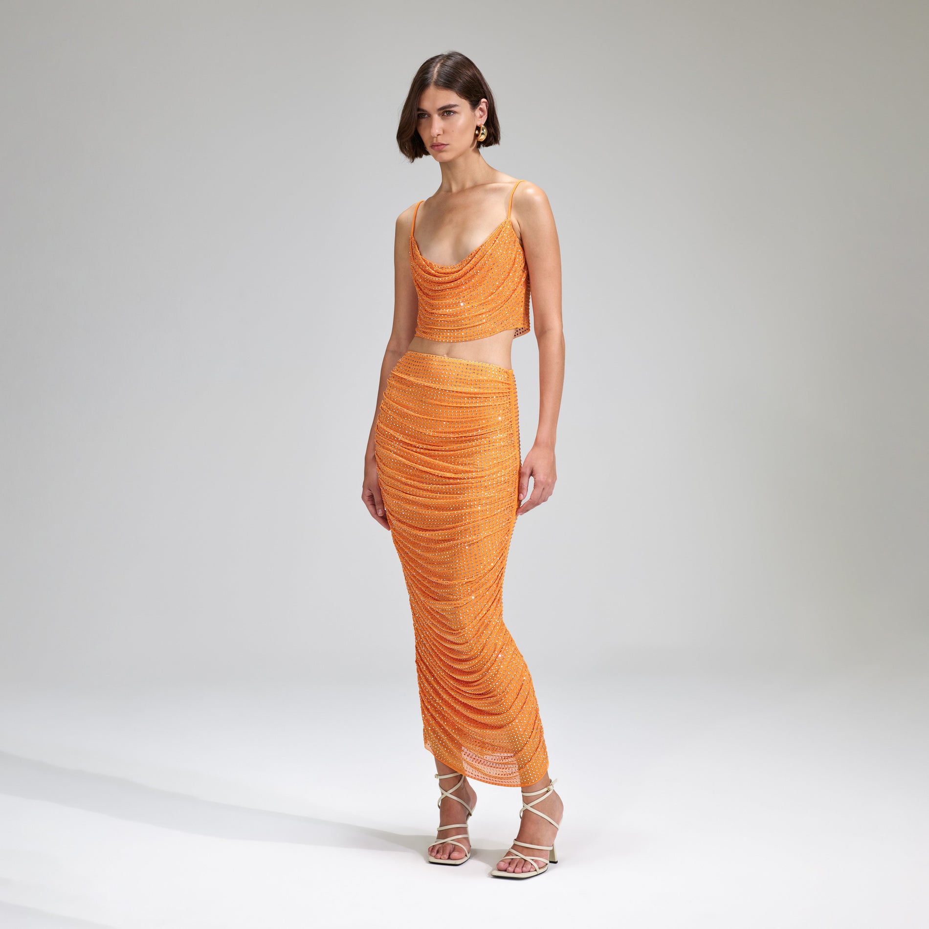 A woman wearing the Orange Rhinestone Mesh Top