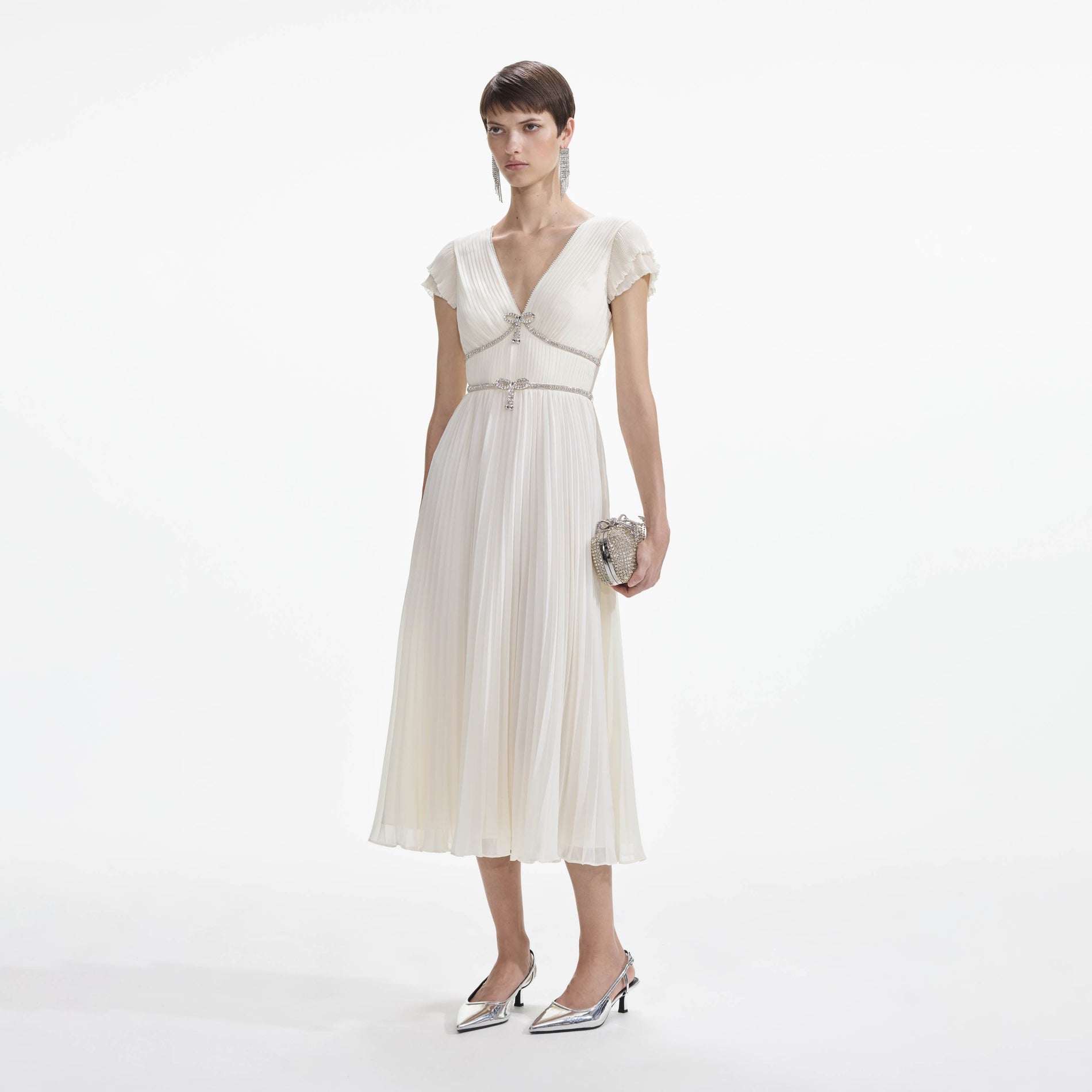 Side view of a woman wearing the Cream Chiffon Pleated Midi Dress