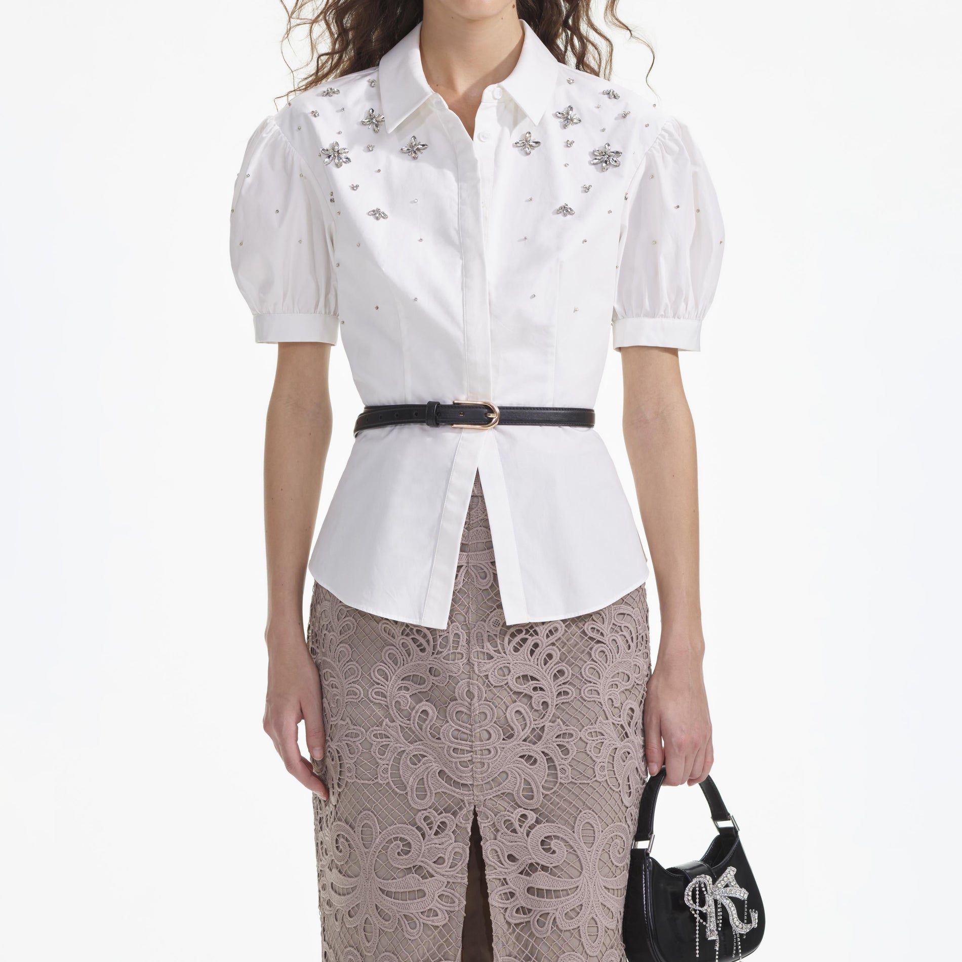 A close up of a woman wearing the White Cotton Embellished Top