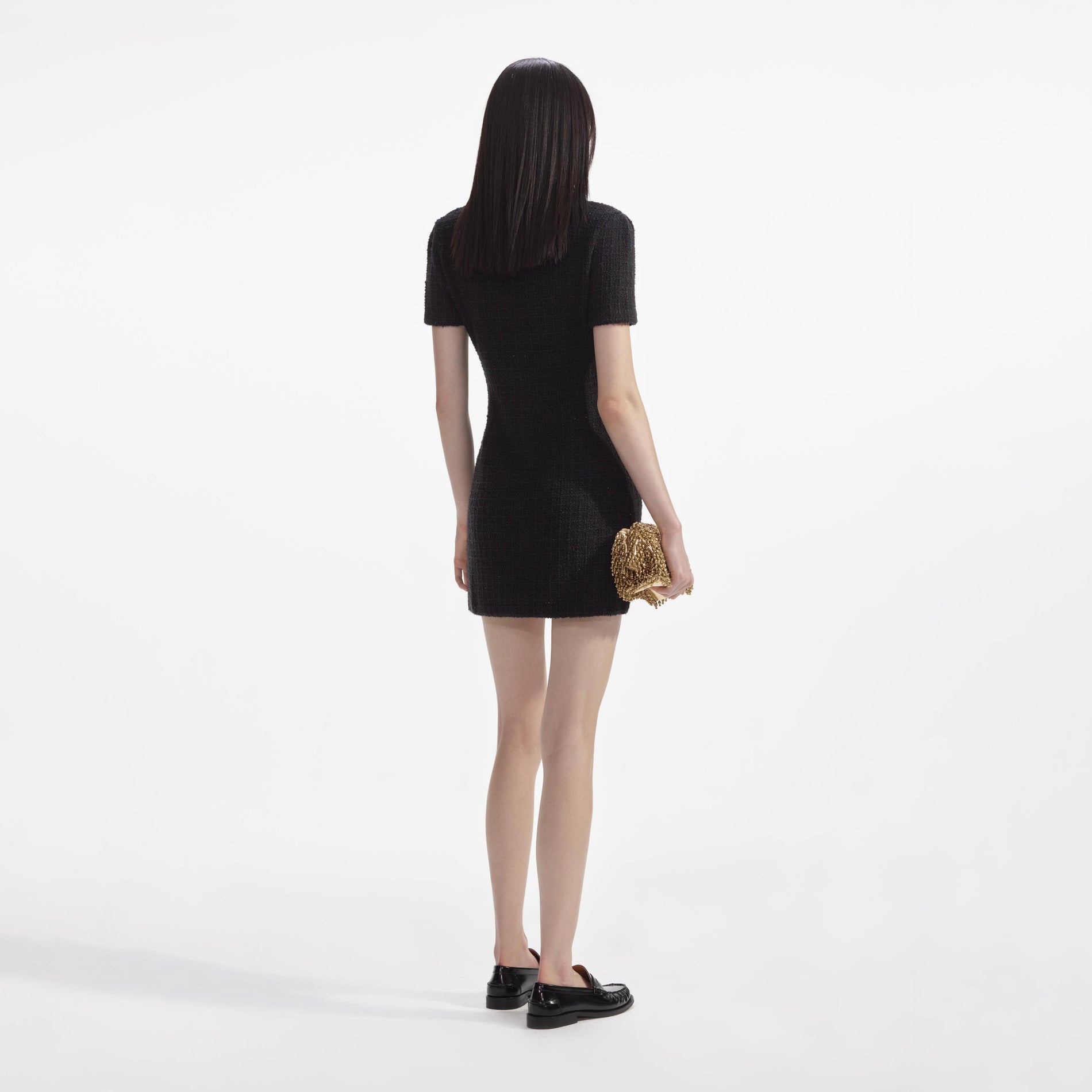 Back view of a woman wearing the Black Jewel Button Knit Mini Dress