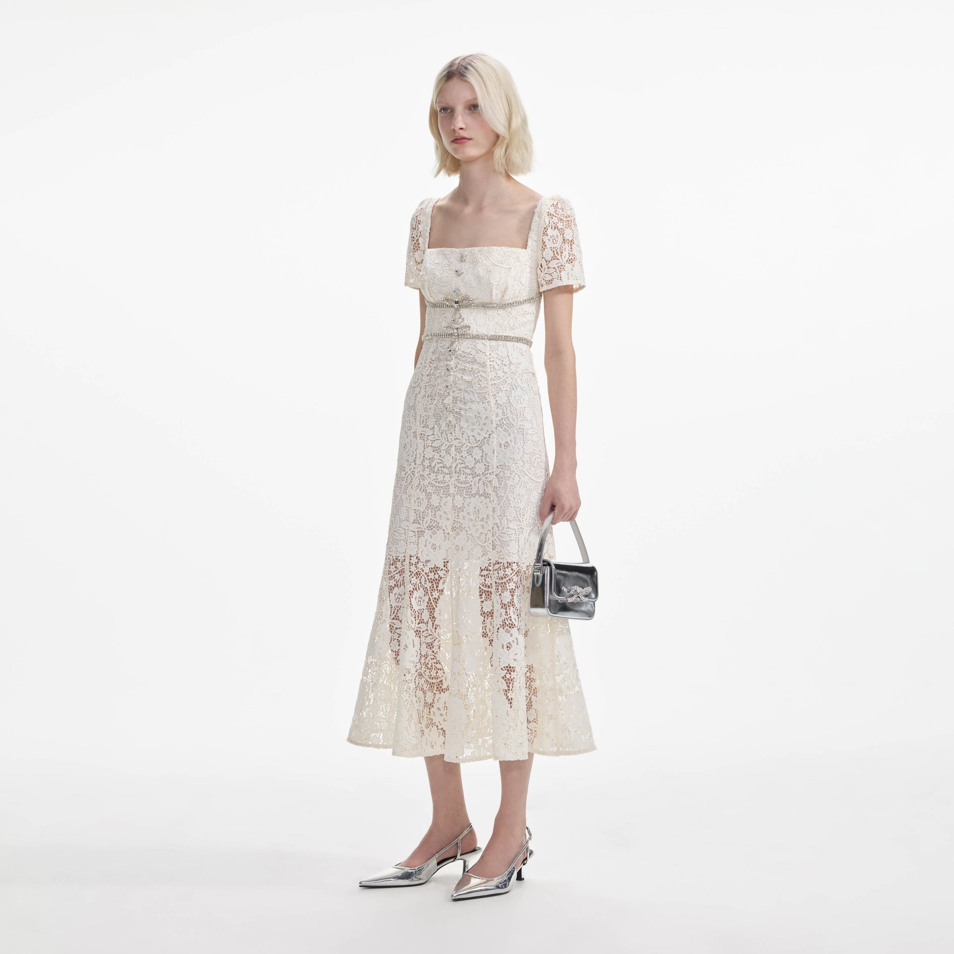Side view of a woman wearing the Cream Lace Diamante Bow Midi Dress