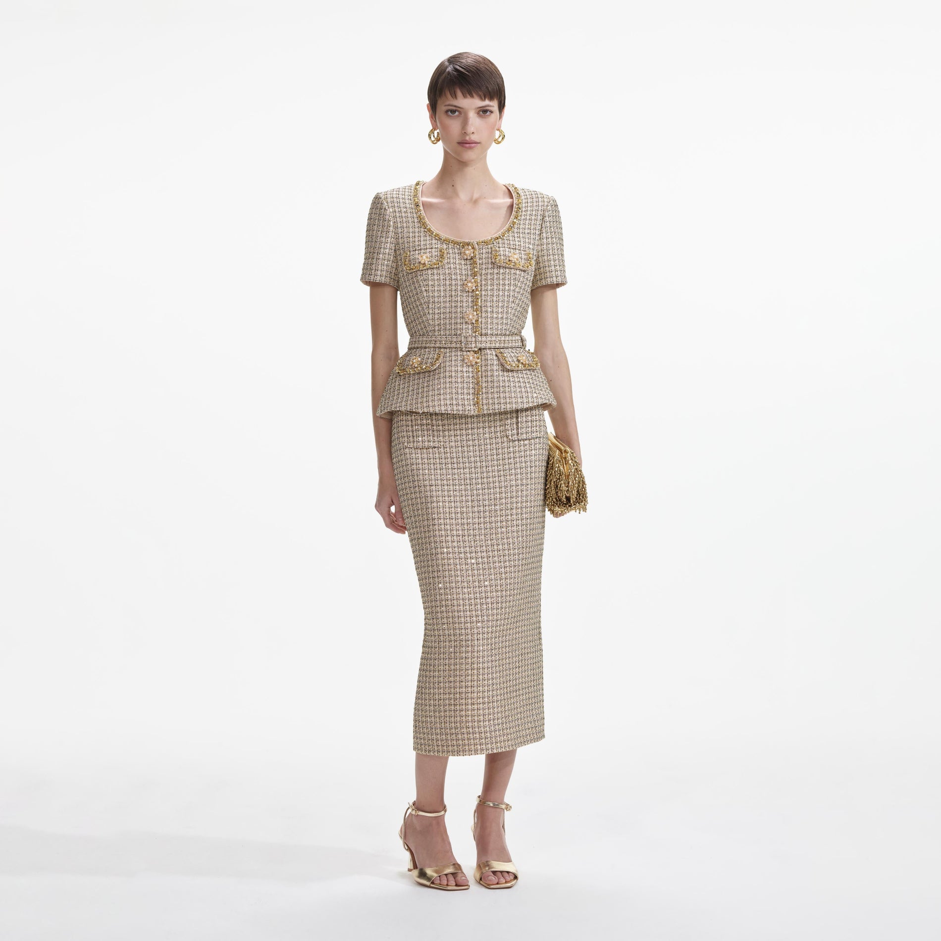 Front view of a woman wearing the Gold Boucle Peplum Top