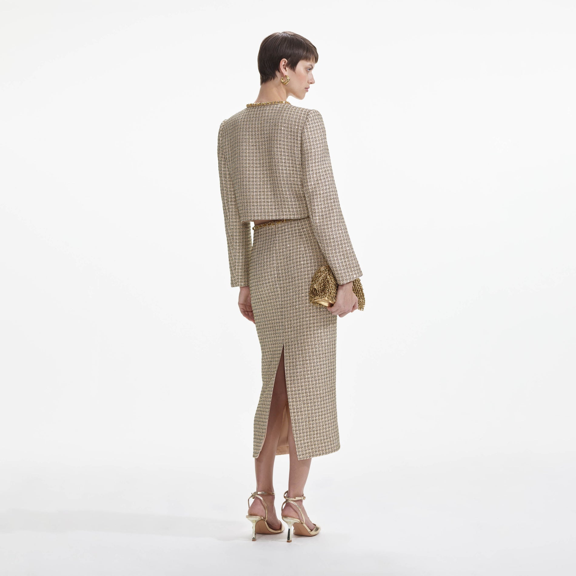 Back view of a woman wearing the Gold Boucle Midi Skirt