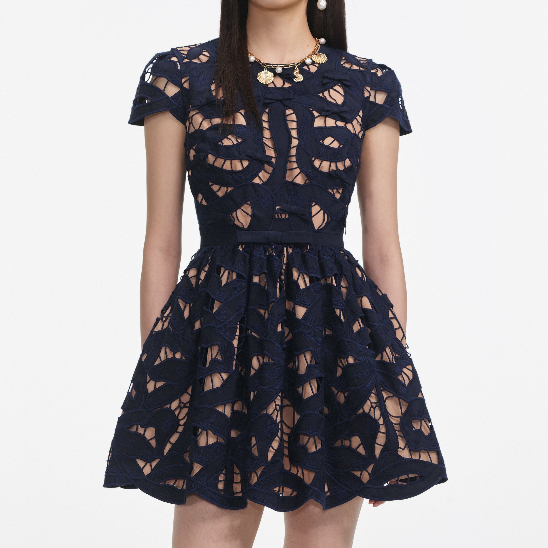 A close up of a woman wearing the Navy Bow Embroidered Mini Dress
