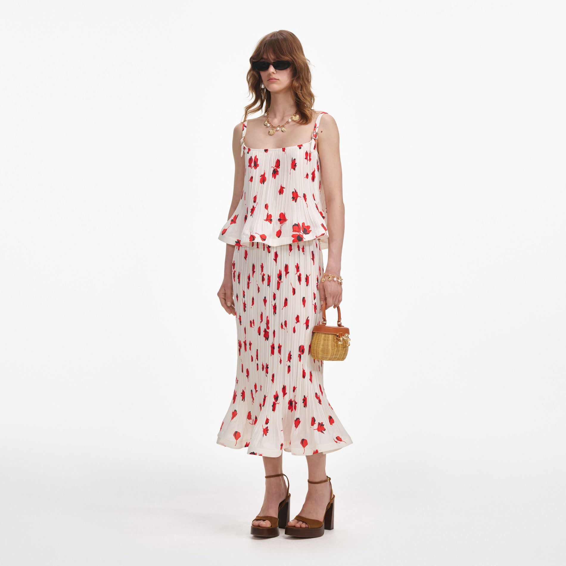 Side view of a woman wearing the White Floral Plisse Midi Skirt
