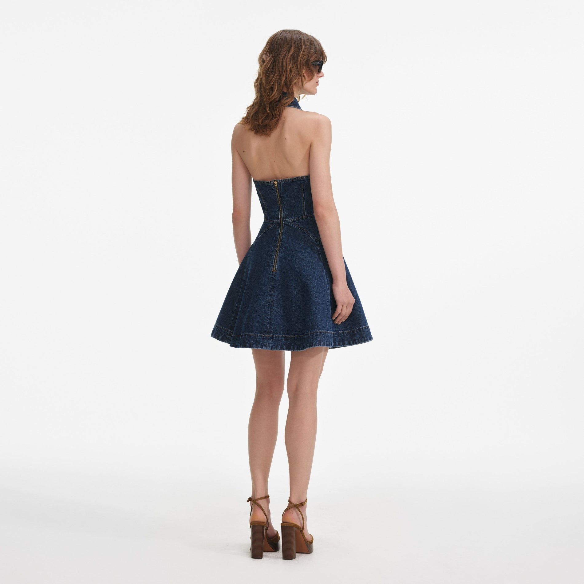 Back view of a woman wearing the Denim Sleeveless Flared Mini Dress