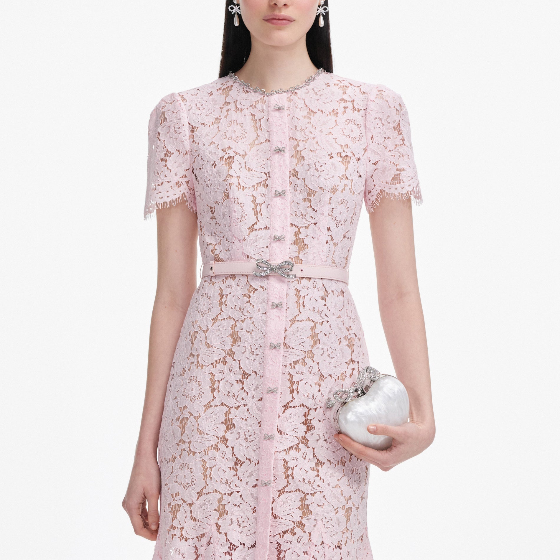 A close up of a woman wearing the Pink Lace Bow Trim Midi Dress