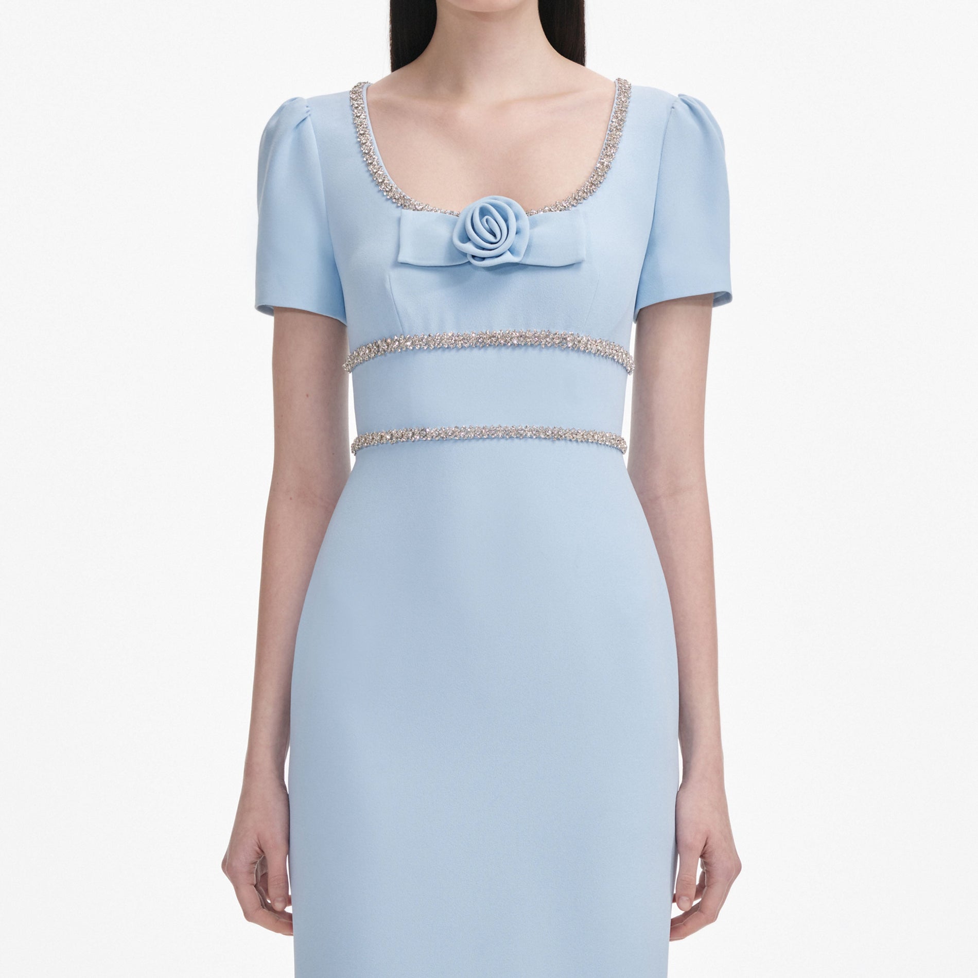 A close up of a woman wearing the Blue Crepe Crystal Trim Maxi Dress