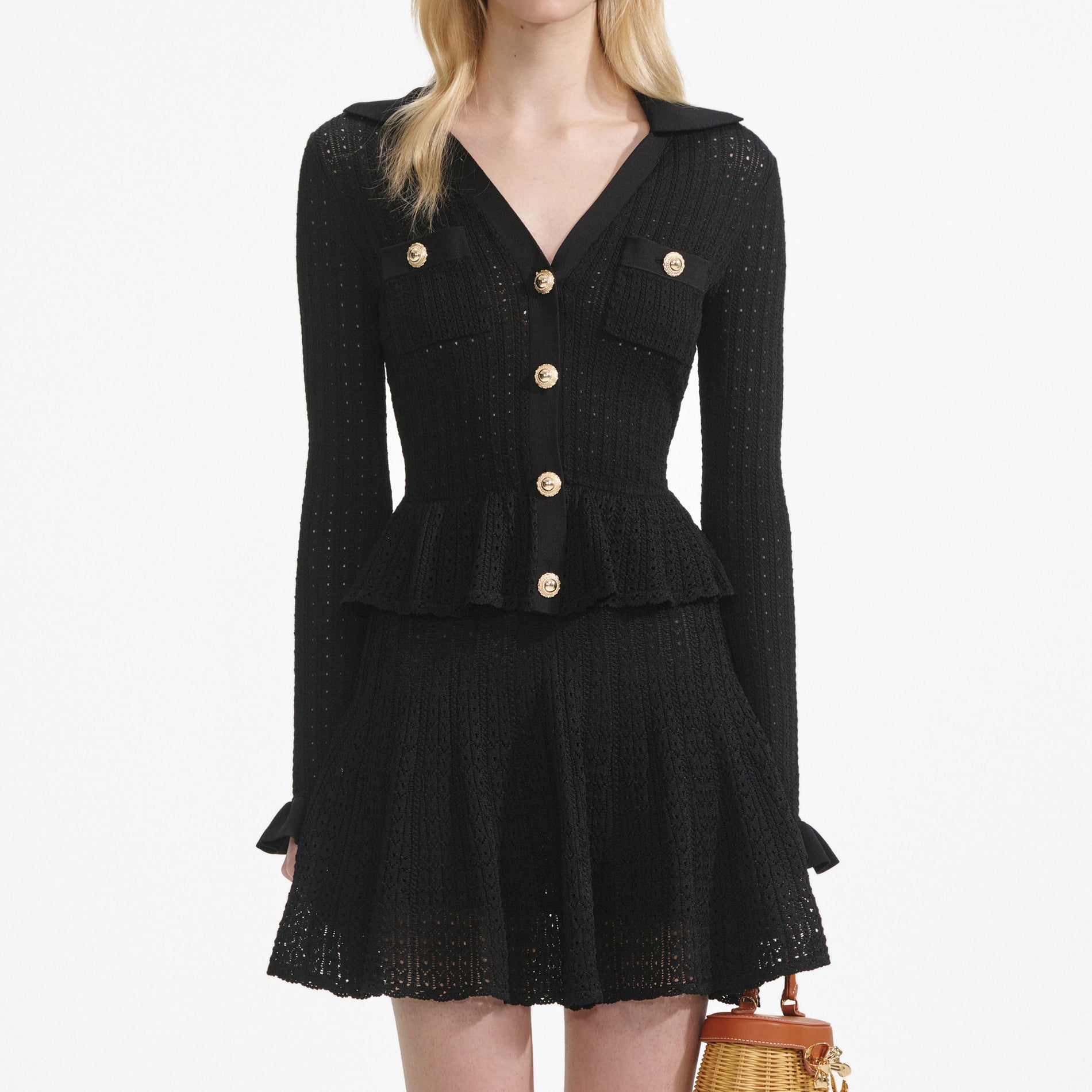 A close up of a woman wearing the Black Pointelle V Neck Knit Mini Dress