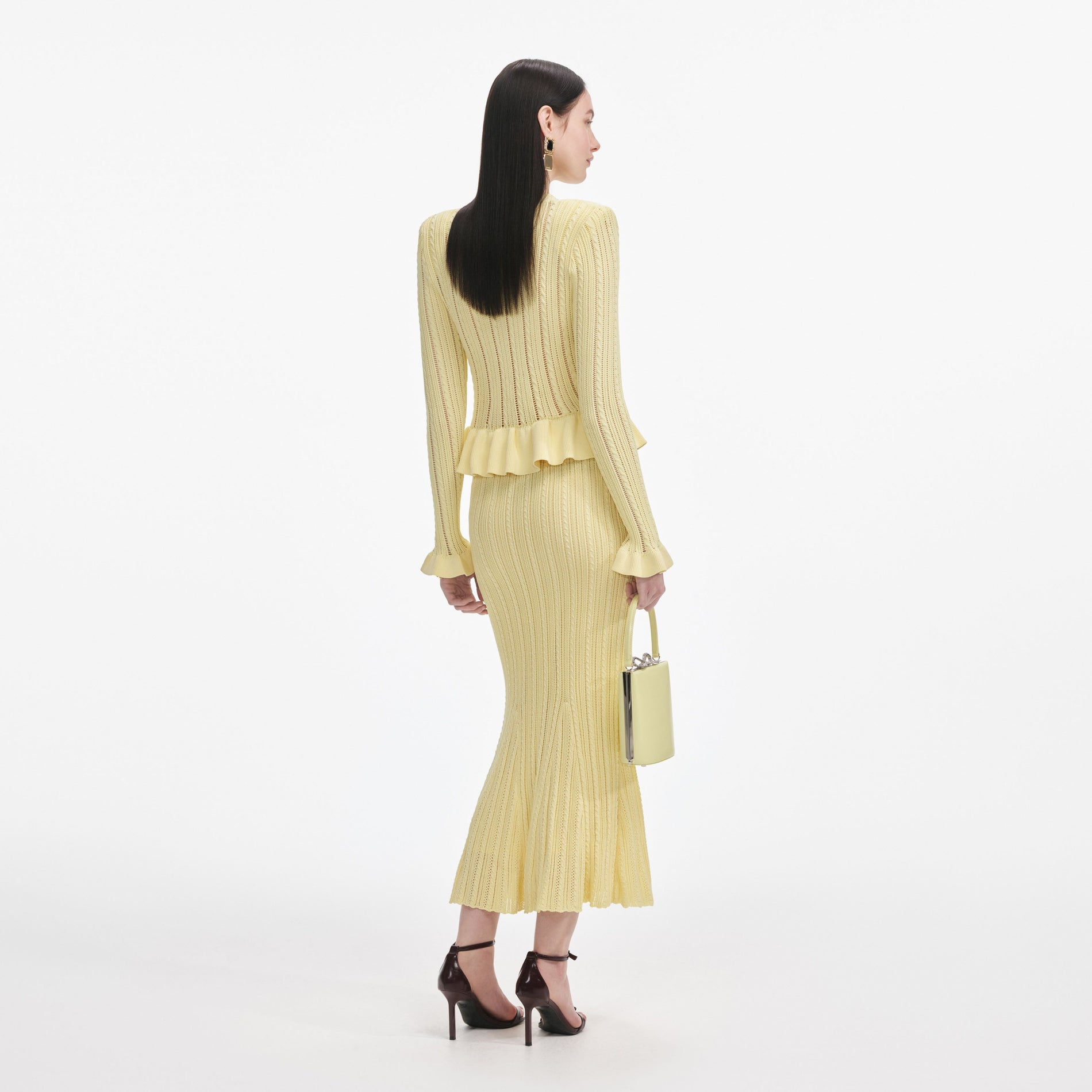 Back view of a woman wearing the Yellow Knit Peplum Midi Dress