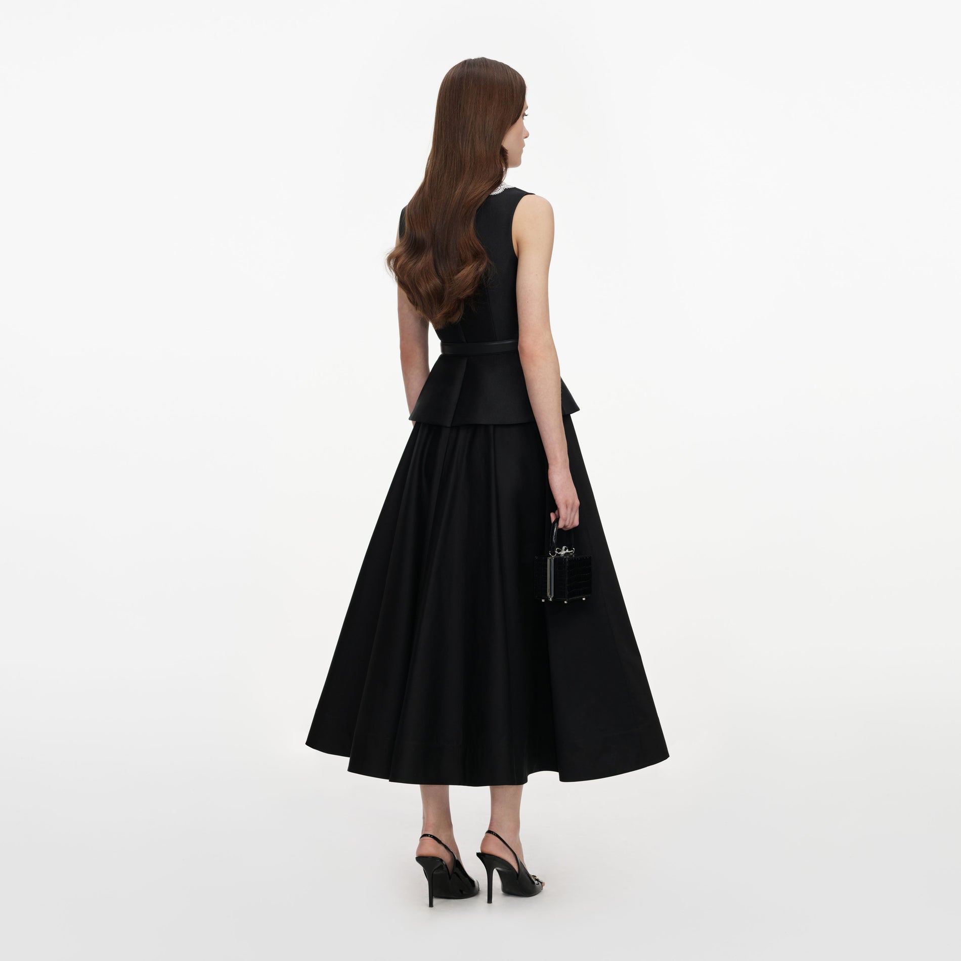 Back view of a woman wearing the Black Taffeta Peplum Midi Dress