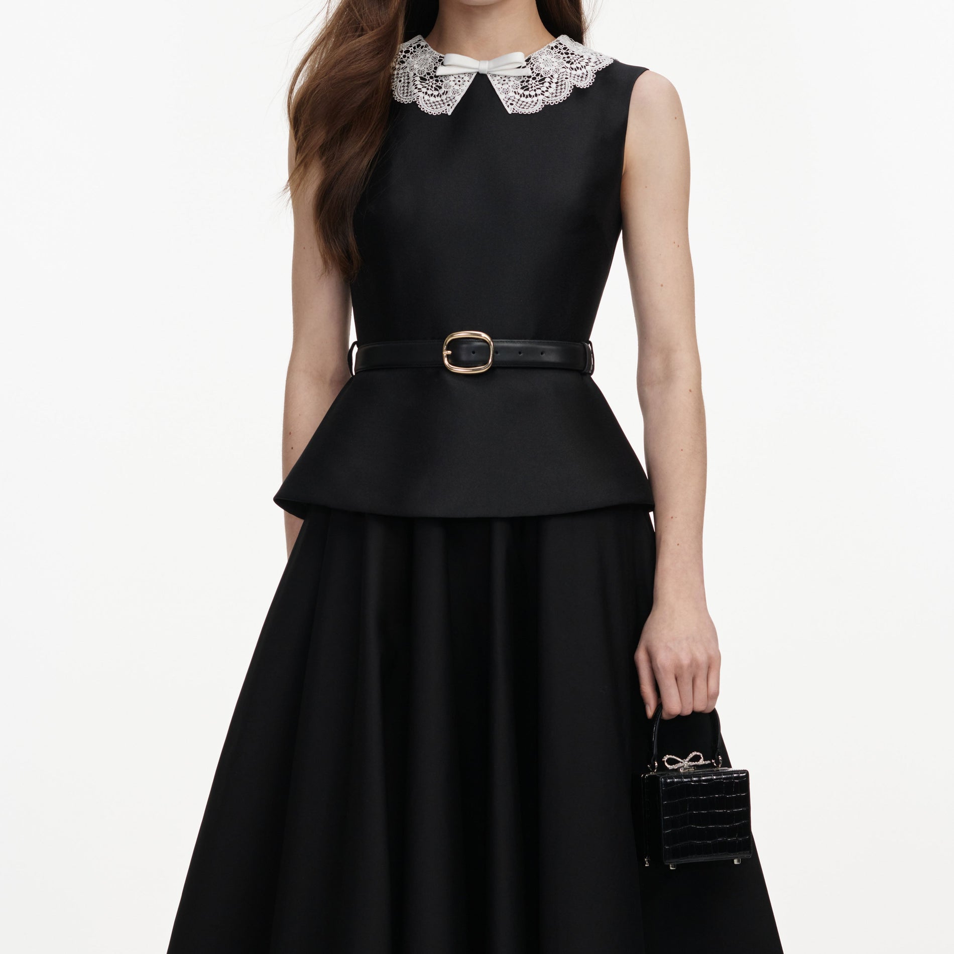 A close up of a woman wearing the Black Taffeta Peplum Midi Dress
