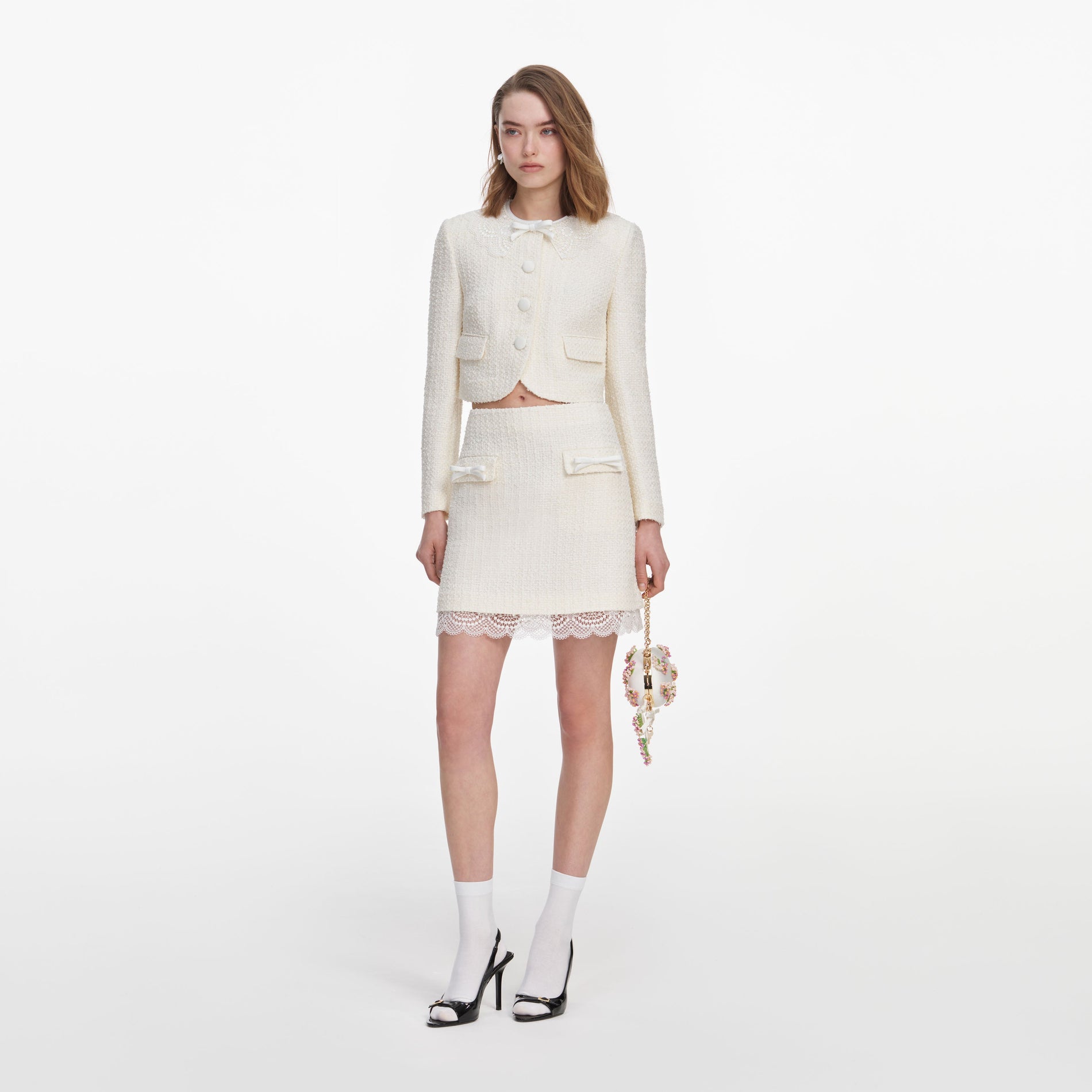 Side view of a woman wearing the Cream Boucle Lace Mini Skirt