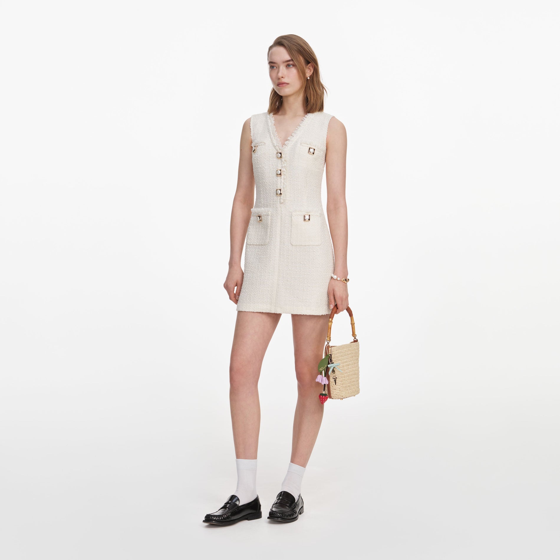 Side view of a woman wearing the Cream Sleeveless Boucle Mini Dress