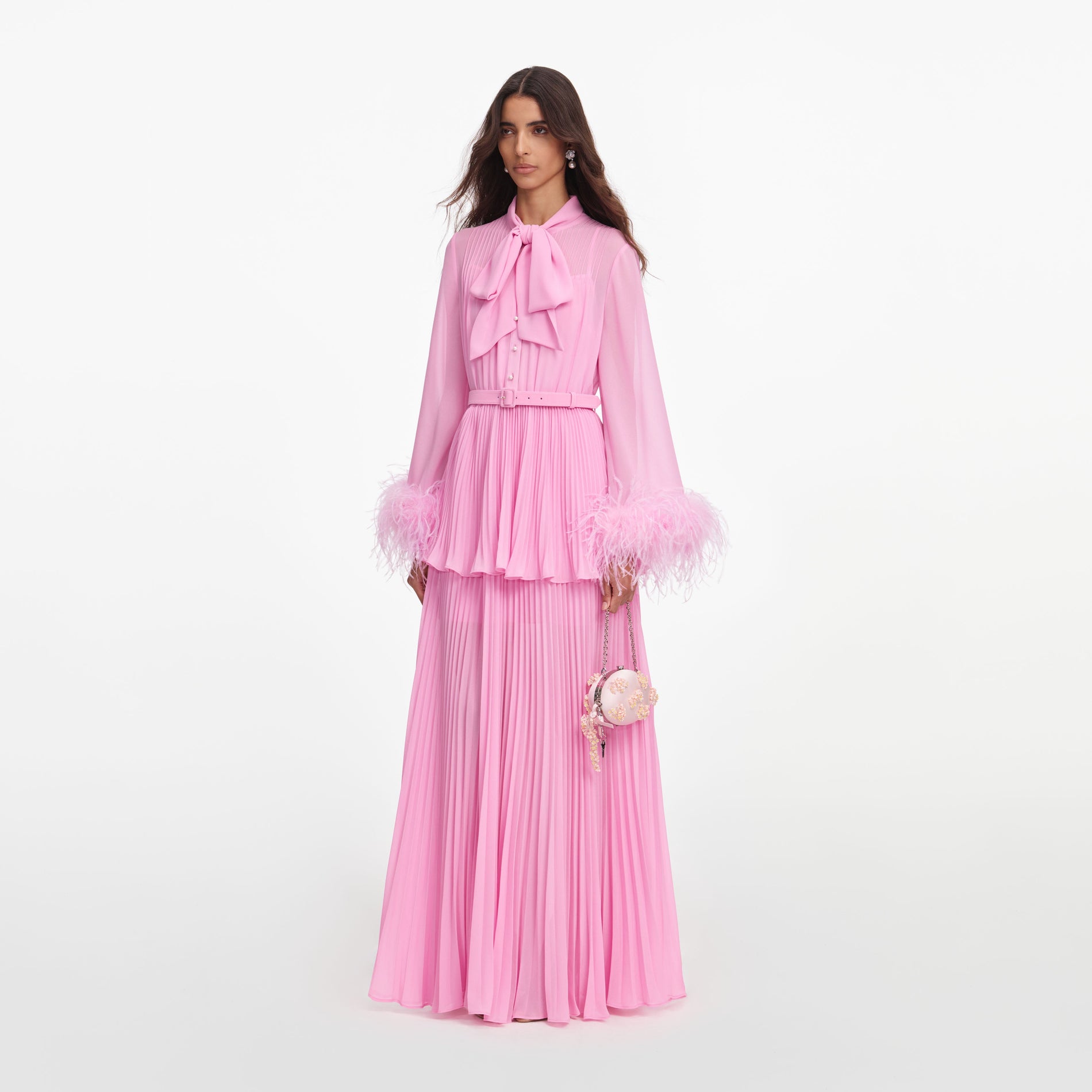 Side view of a woman wearing the Pink Georgette Feather Cuff Maxi Dress