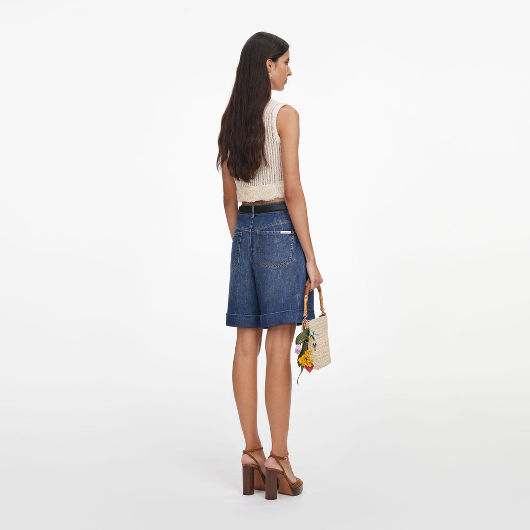 Back view of a woman wearing the Cream Crochet Flower Knit Top