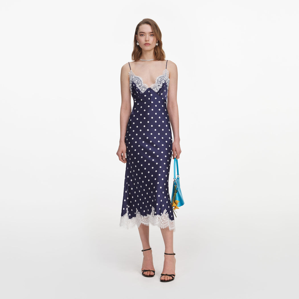 Front view of a woman wearing the Navy Polka Dot Satin Midi Dress