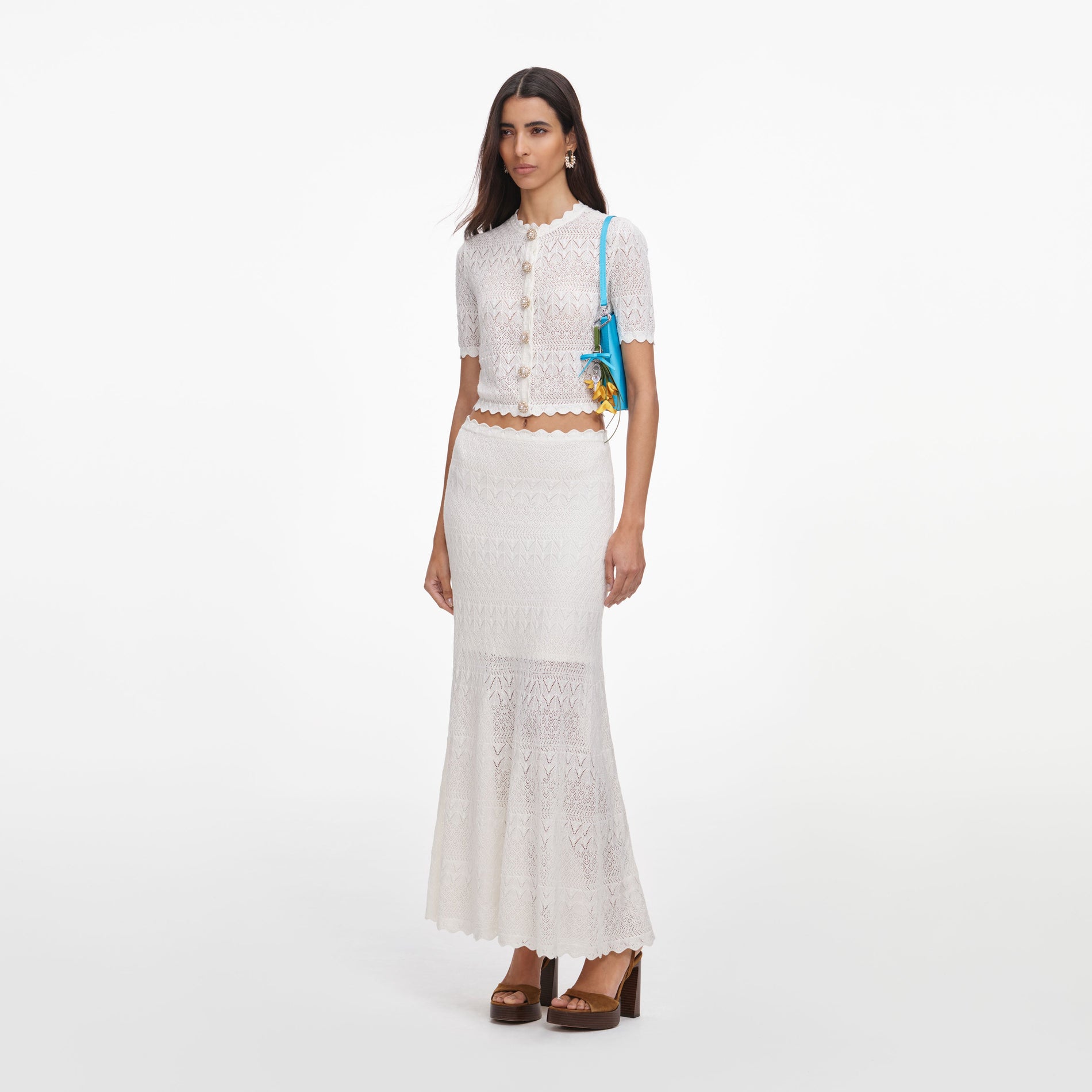 Side view of a woman wearing the White Pointelle Knit Midi Skirt