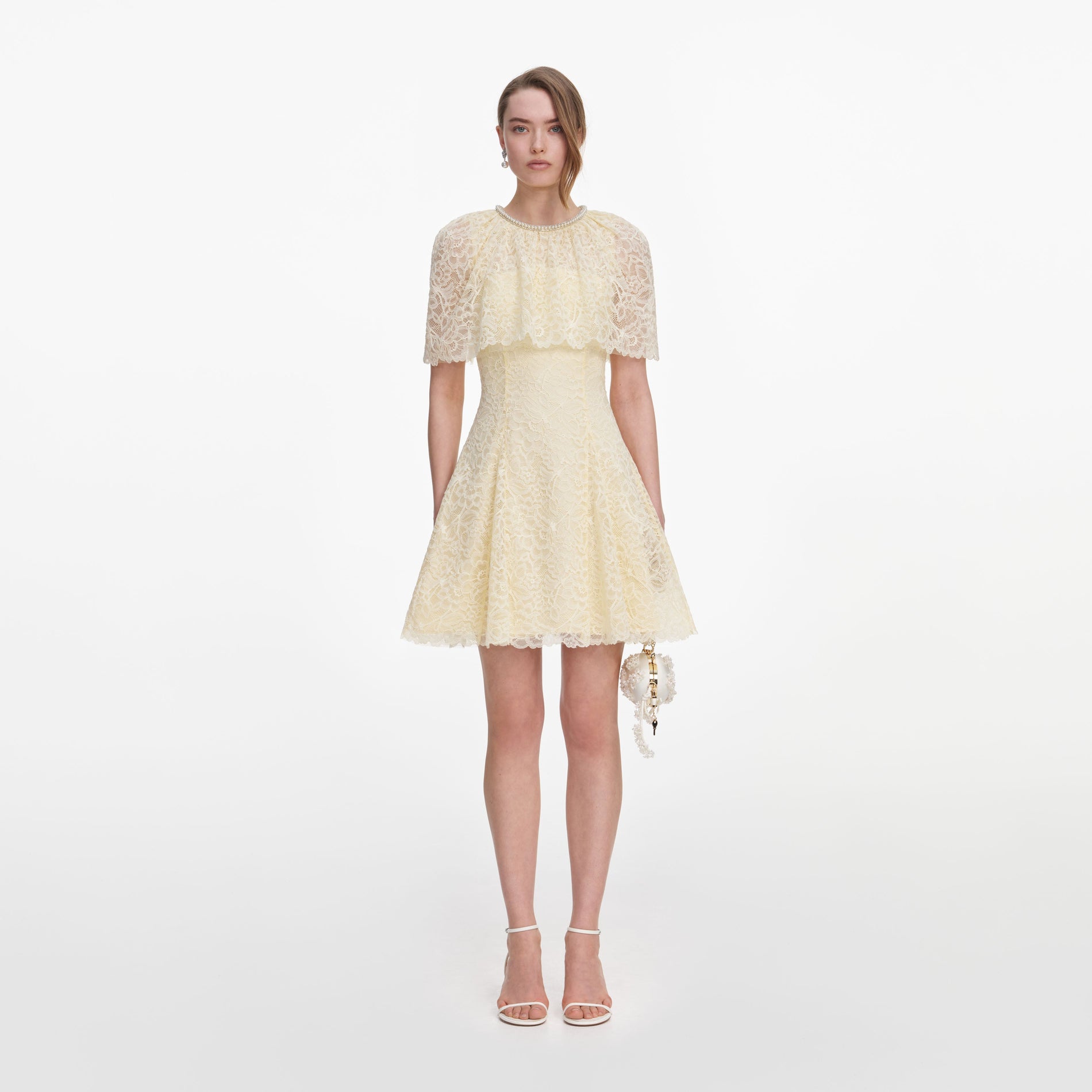 Front view of a woman wearing the Yellow Lace Cape Mini Dress