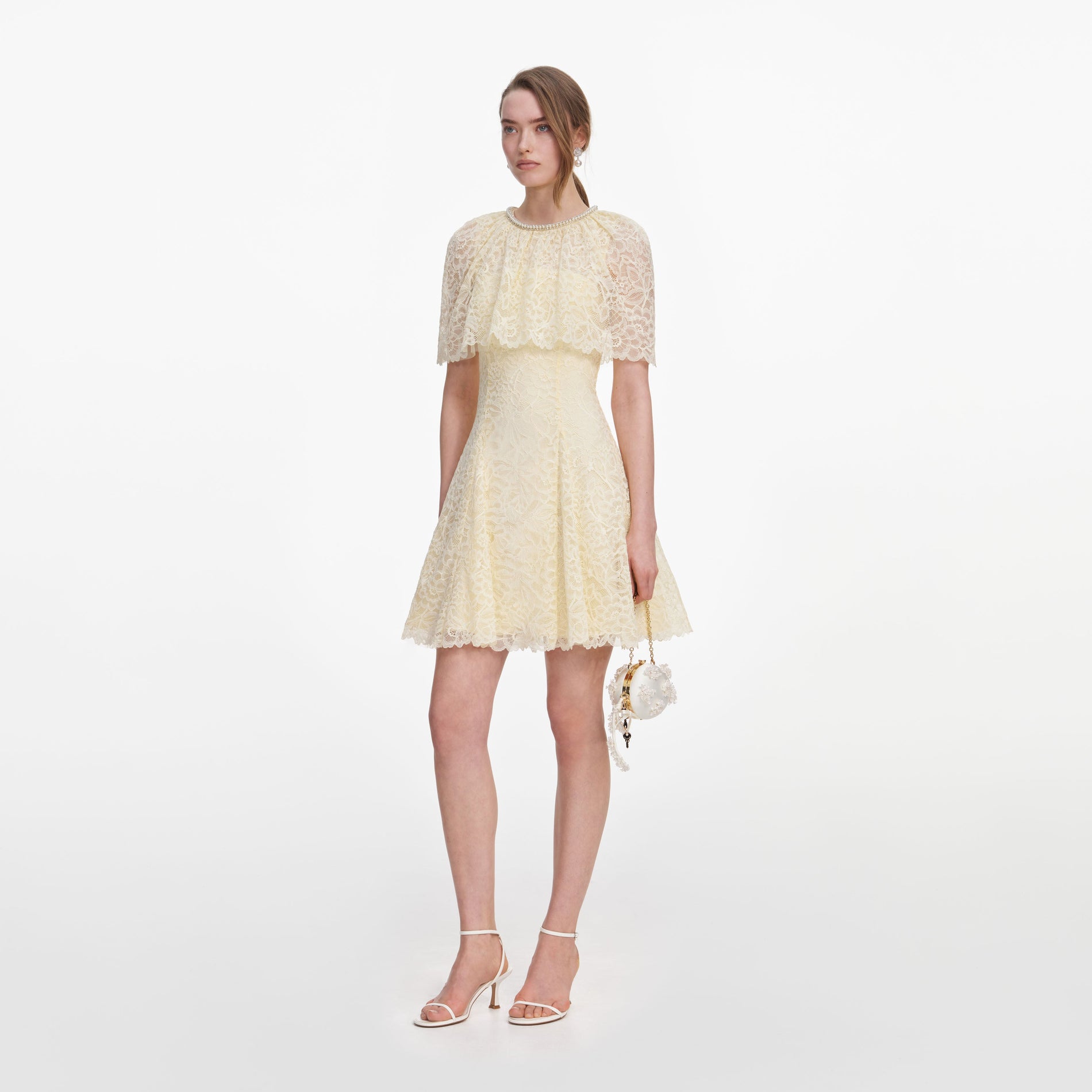 Side view of a woman wearing the Yellow Lace Cape Mini Dress