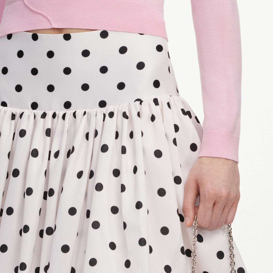 A close up of a woman wearing the Cream Polka Dot Taffeta Midi Skirt