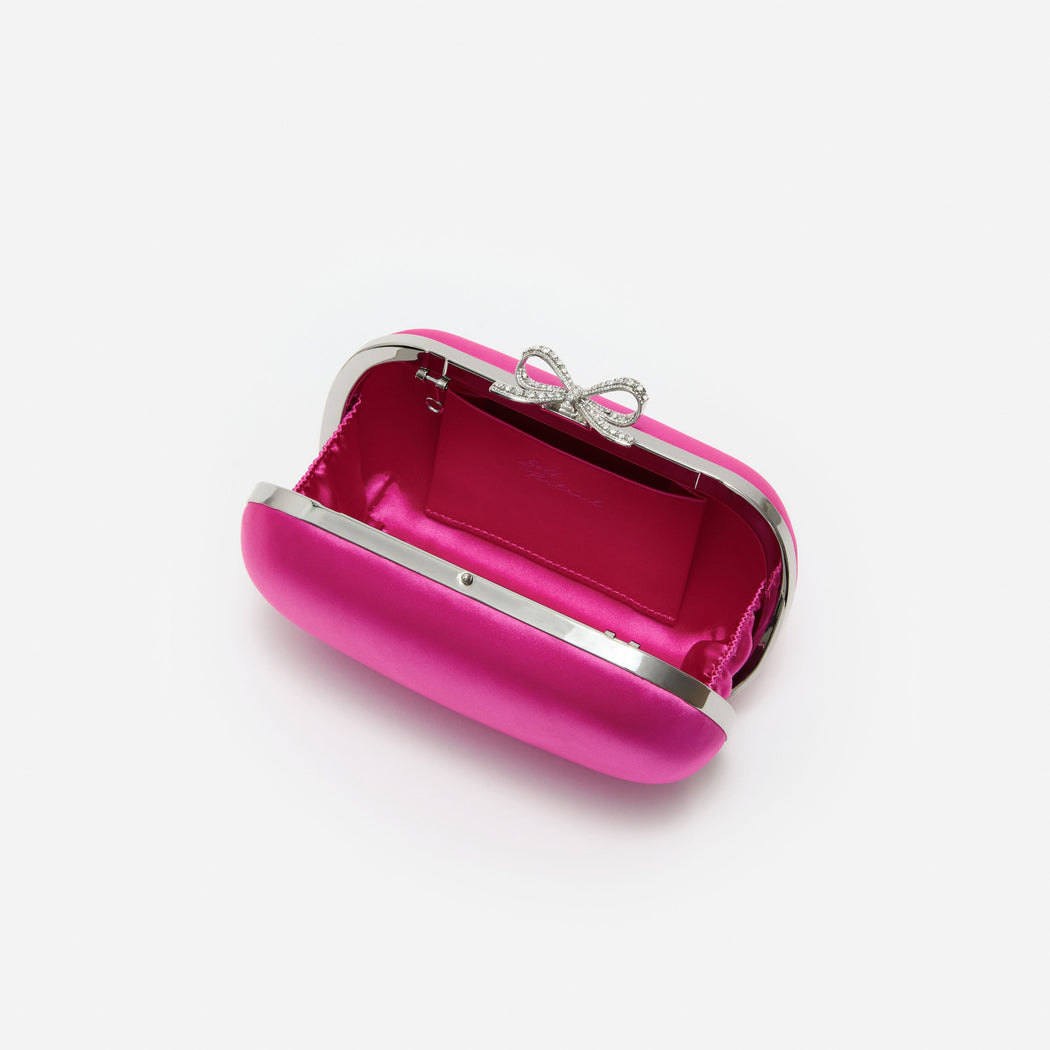 Open fuchsia satin clutch bag with a crystal bow clasp