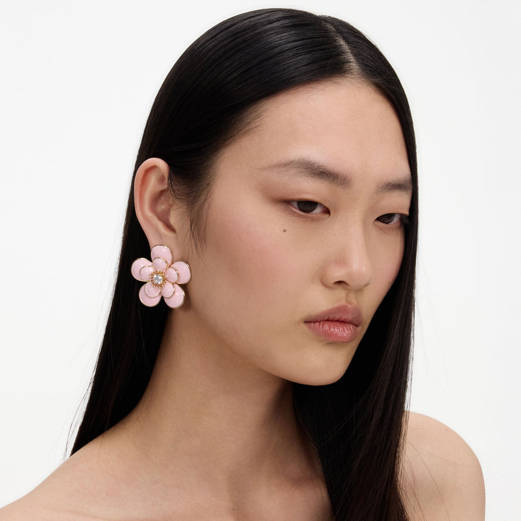 A close up of a woman wearing the Pink Enamel Flower Earrings
