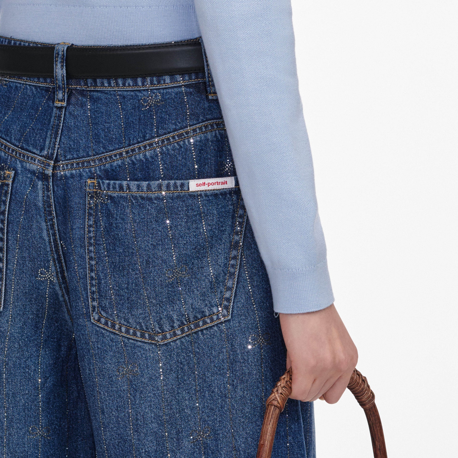 A close up of a woman wearing the Rhinestone Stripe Denim Shorts