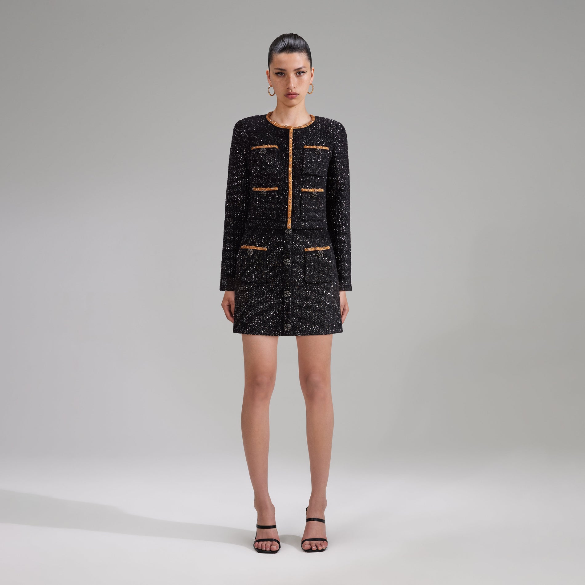 A woman wearing the Black Sequin Knit Mini Skirt