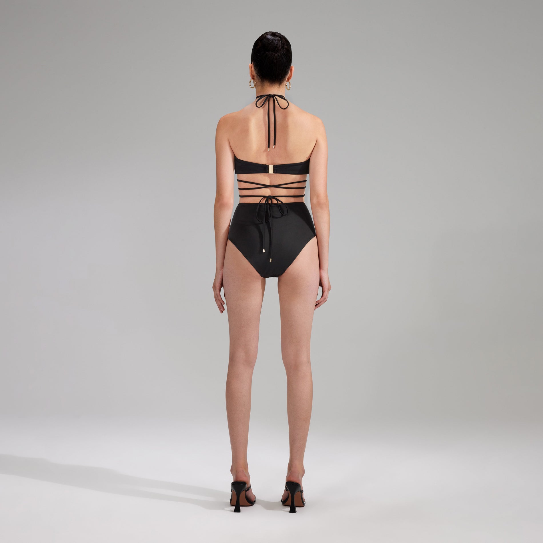 Back view of a woman wearing the Black High Cut Bikini Brief