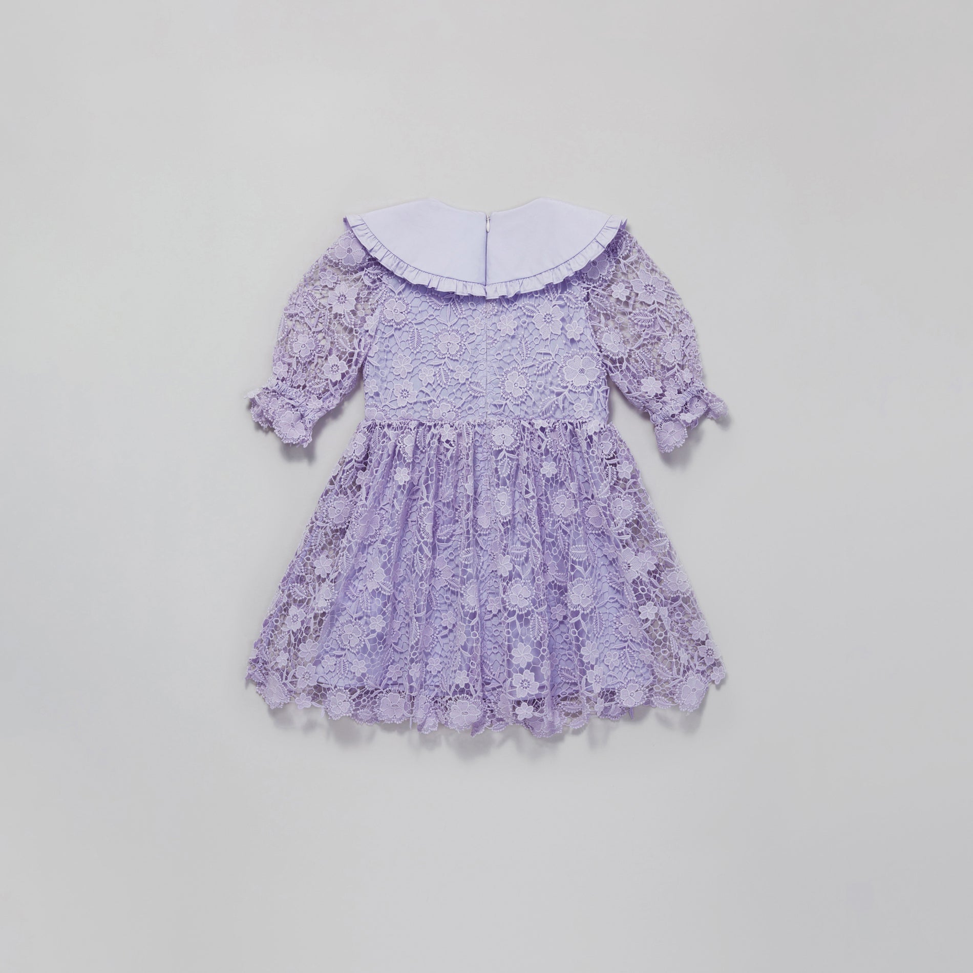 Side view of a woman wearing the Lilac Lace Mini Dress