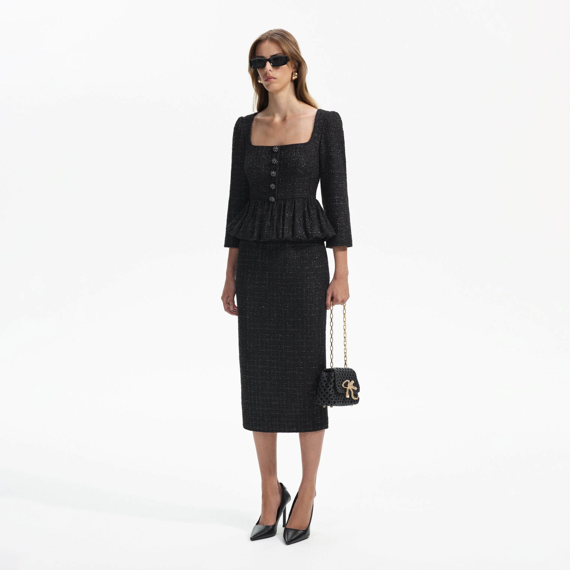 Side view of a woman wearing the Black Boucle Peplum Midi Dress