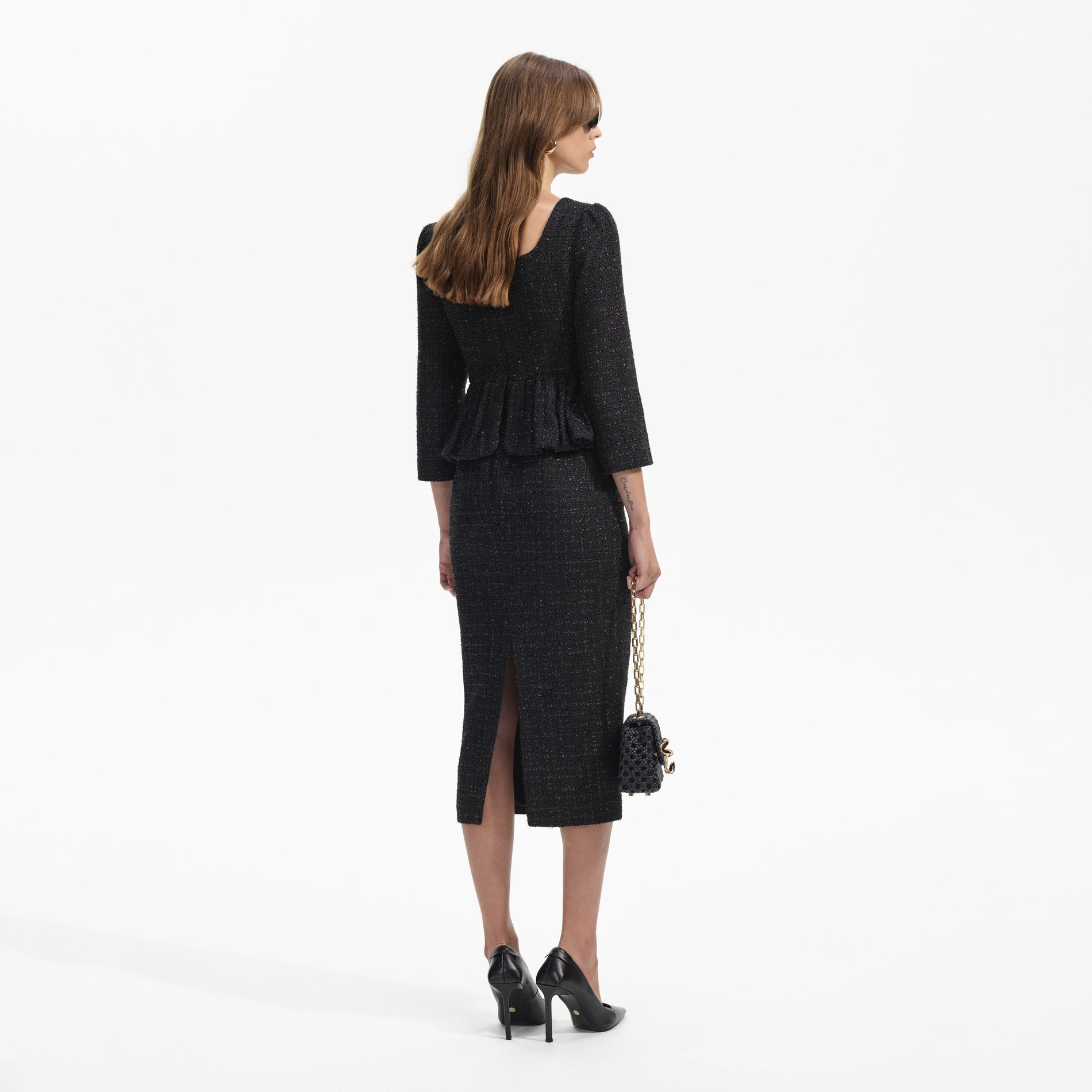 Back view of a woman wearing the Black Boucle Peplum Midi Dress
