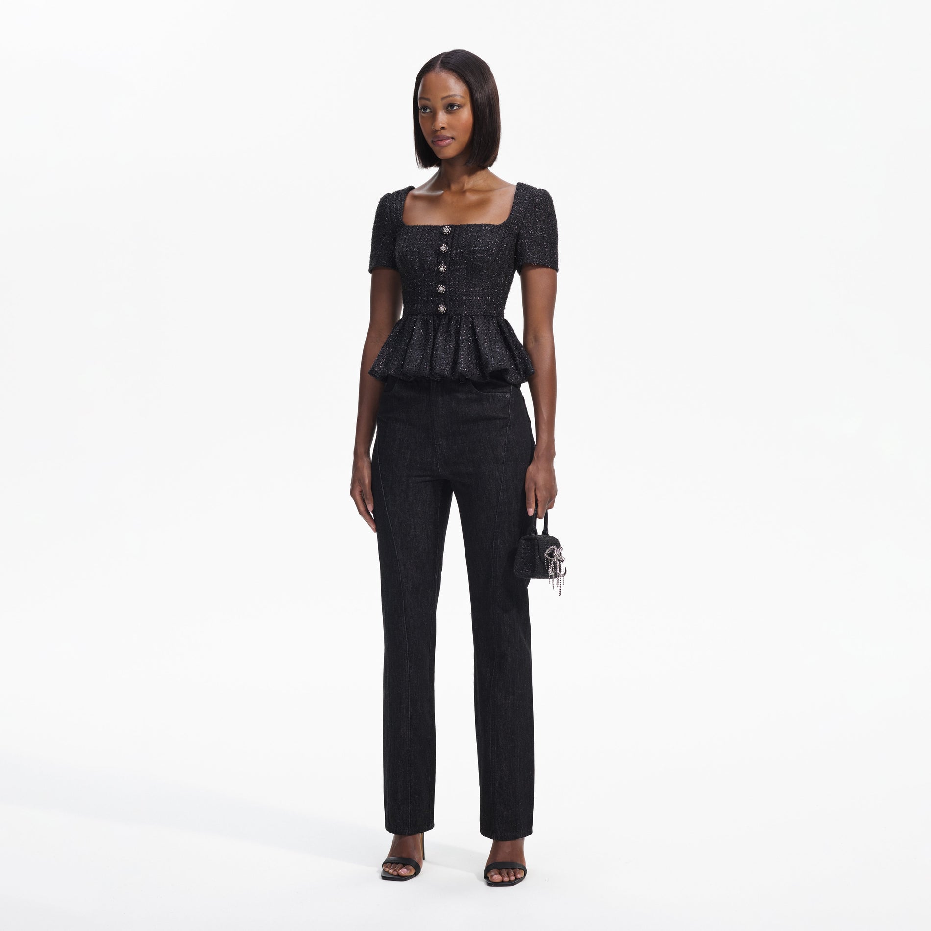 Side view of a woman wearing the Black Boucle Peplum Top