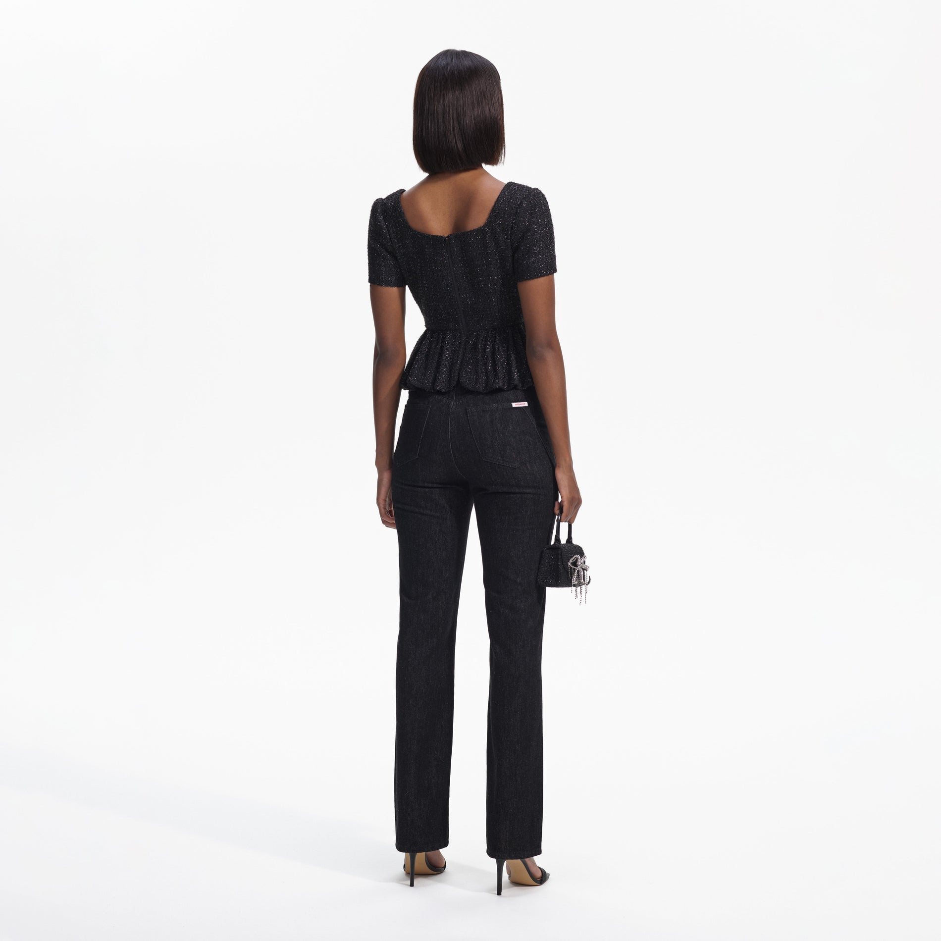 Back view of a woman wearing the Black Boucle Peplum Top