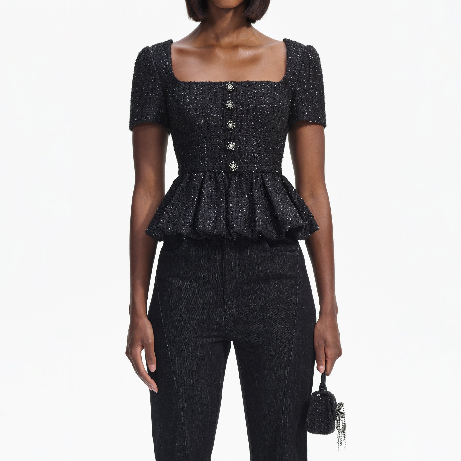 A close up of a woman wearing the Black Boucle Peplum Top