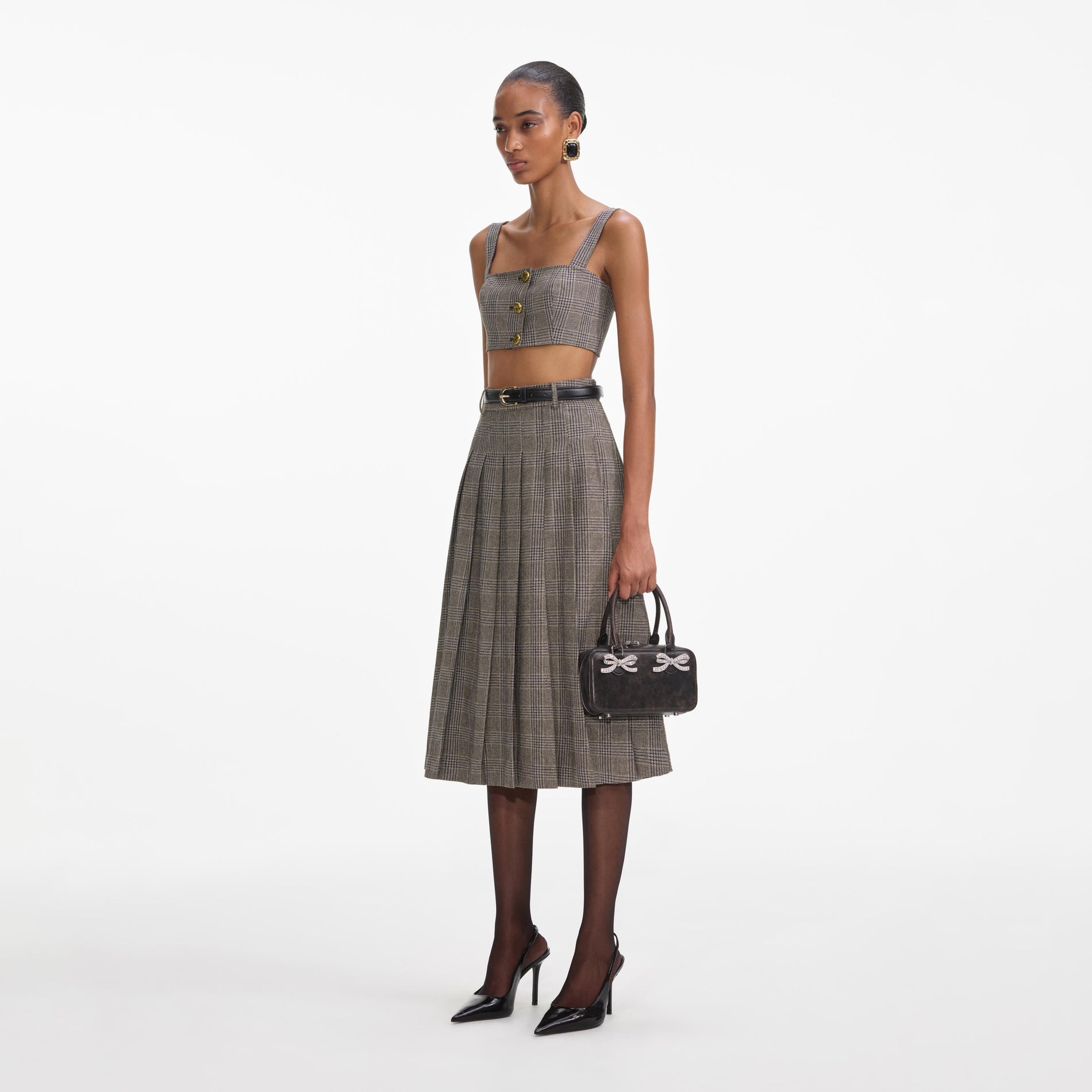 Side view of a woman wearing the Brown Check Pleated Midi Skirt