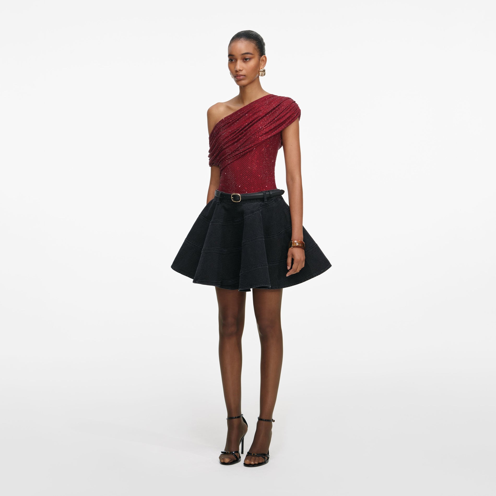 Side view of a woman wearing the Black Flared Denim Mini Skirt