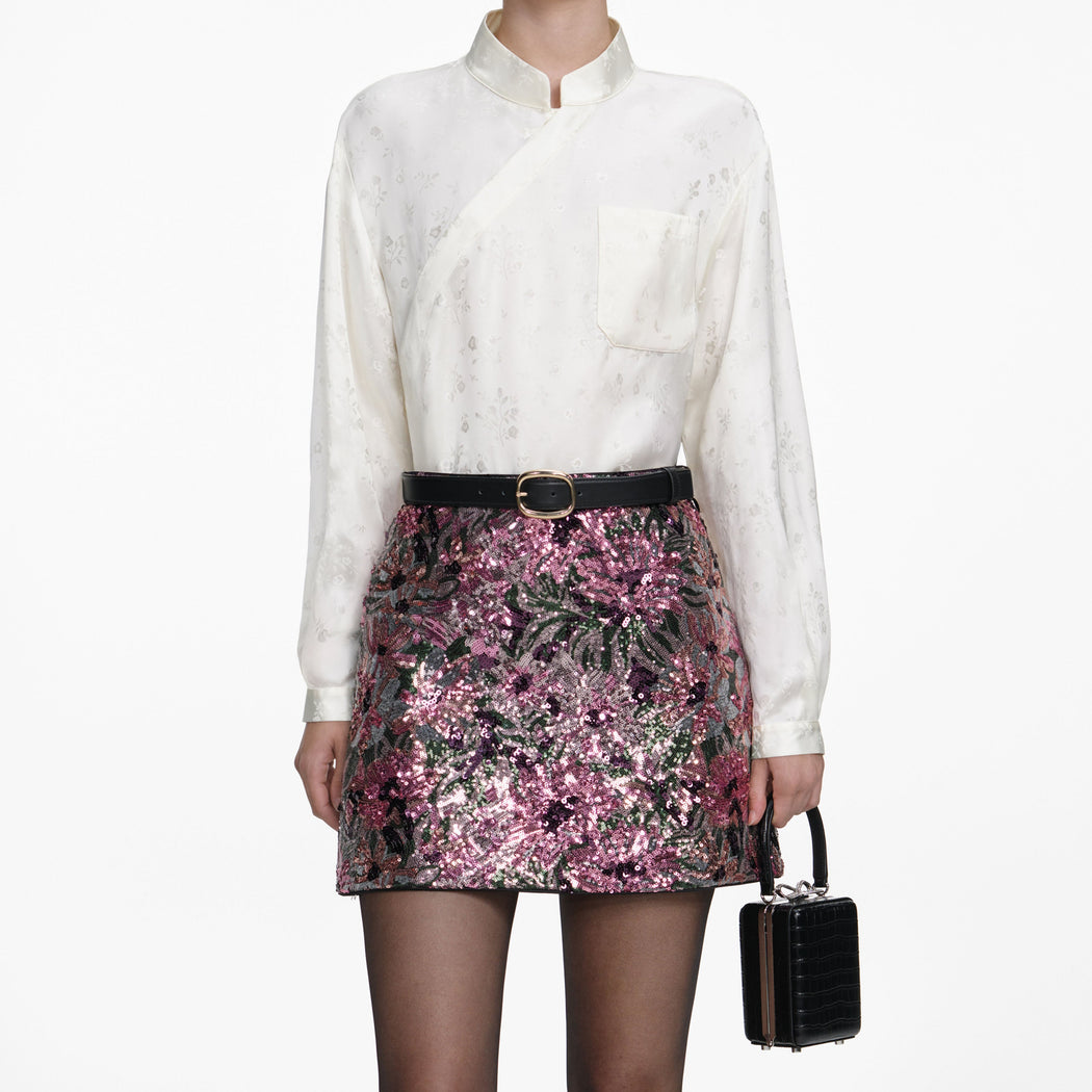 A close up of a woman wearing the Floral Sequin Mini Skirt