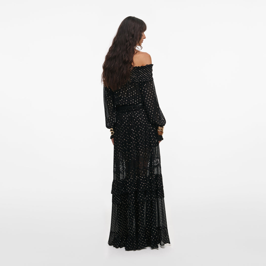 Back view of a woman wearing the Black And Gold Chiffon Lace Maxi Skirt