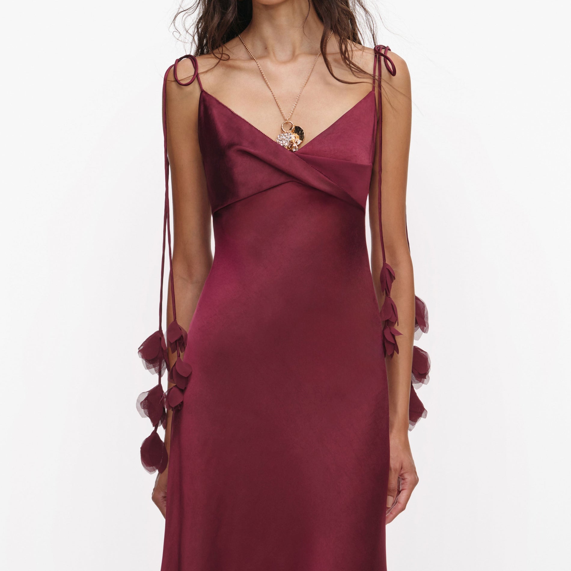 A close up of a woman wearing the Burgundy Satin Flower Midi Dress